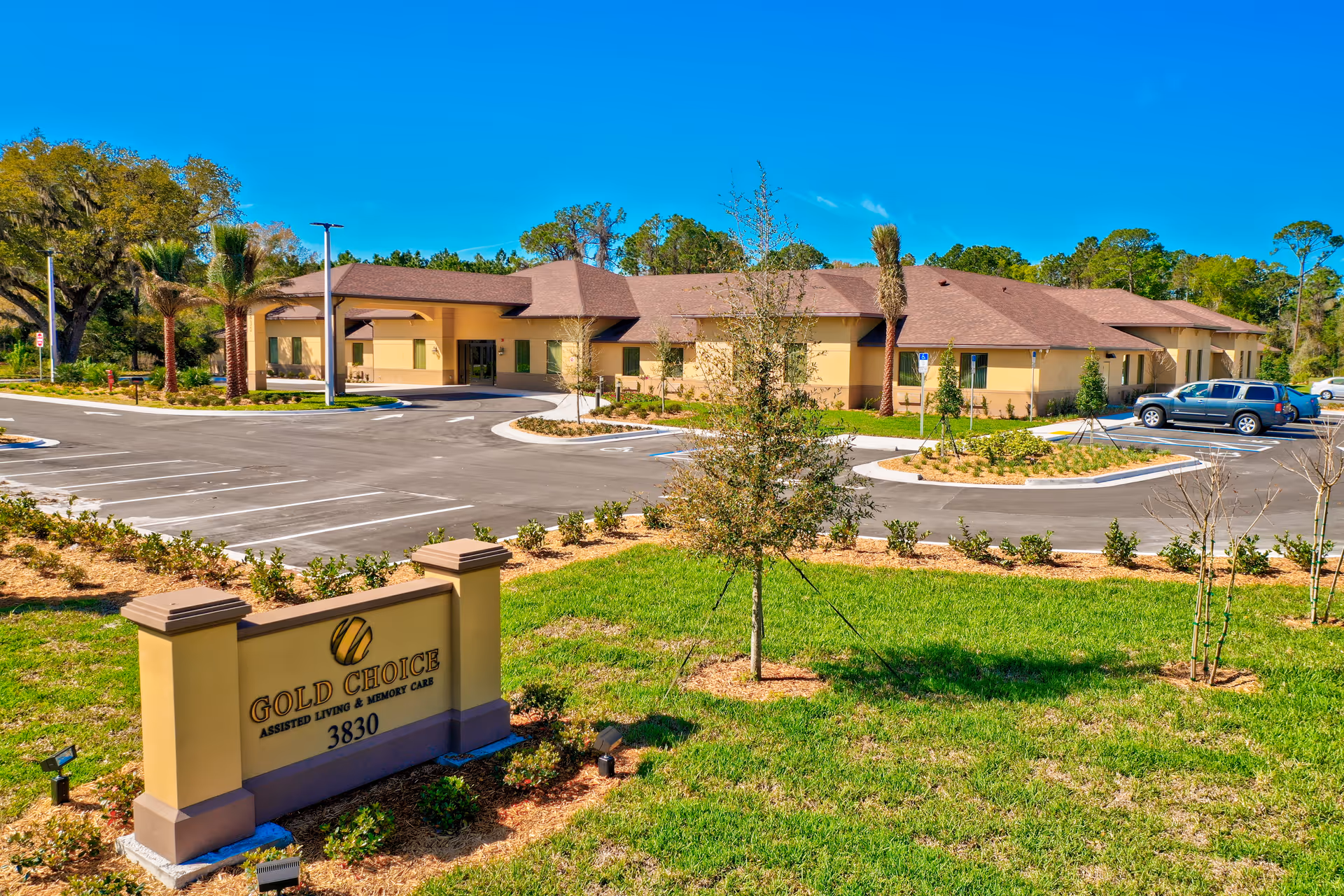 Exterior view of Gold Choice Palm Coast Assisted Living & Memory Care facility with parking lot.