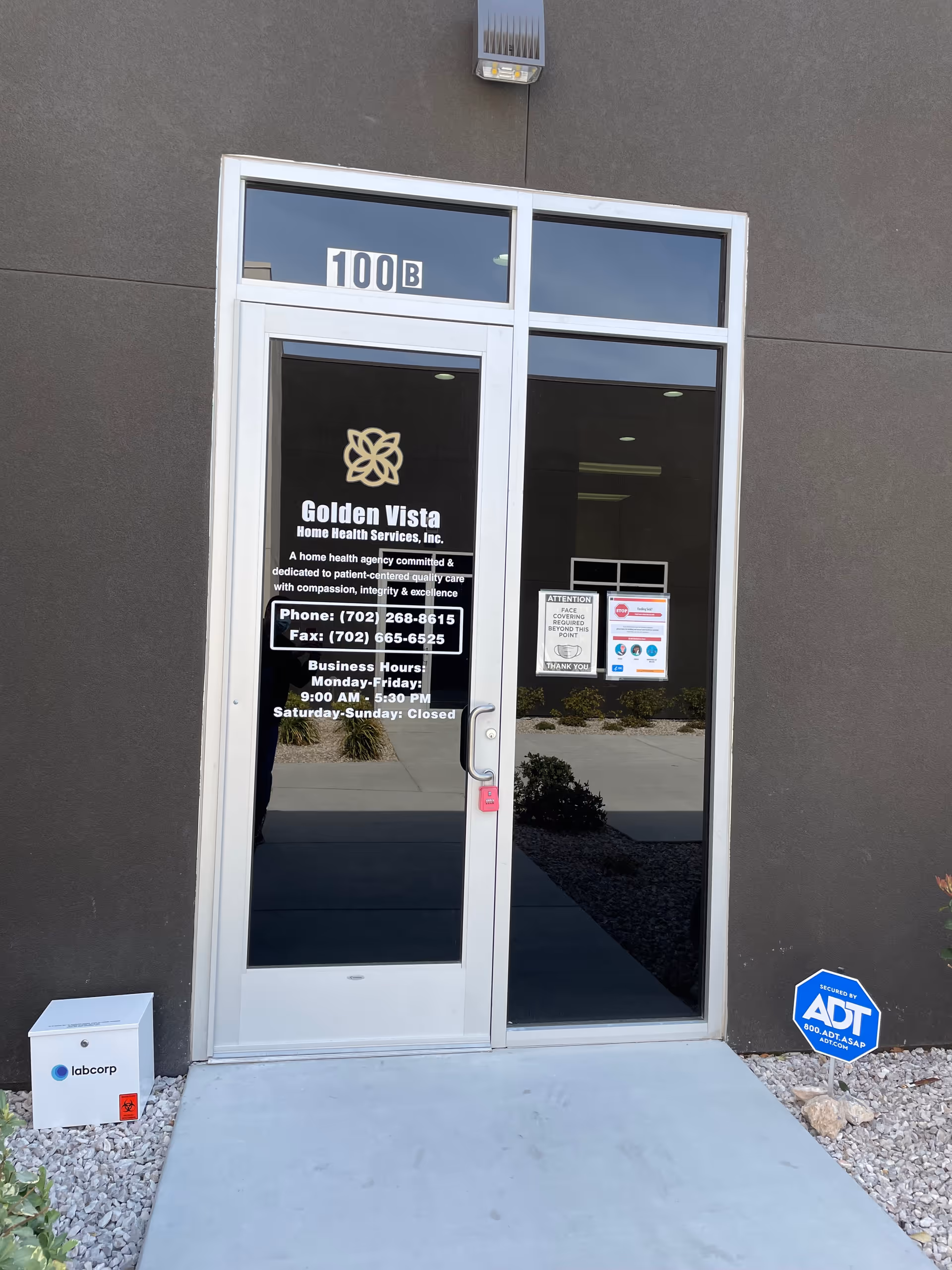 Glass entrance door labeled 100B with Golden Vista Home Health Services signage on a gray wall.
