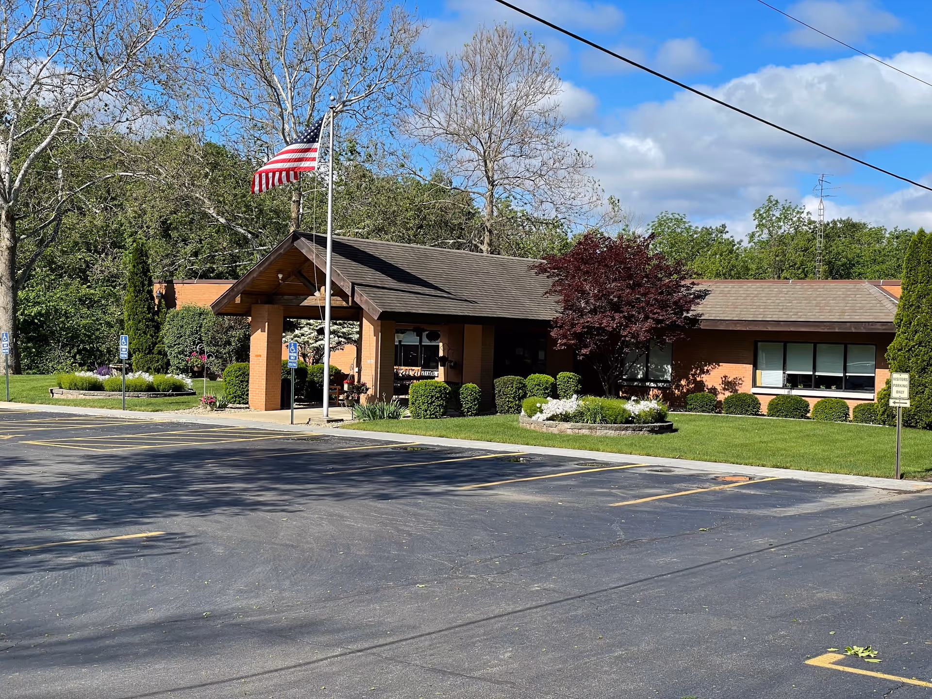 Exterior view of Mount Zion Health and Rehab Center with flag, entrance, and landscaped grounds.