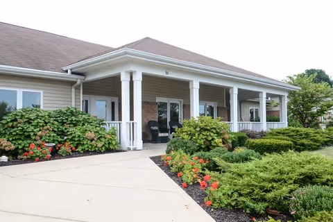 Front view of Autumn Glen senior living facility with a covered porch and landscaping.