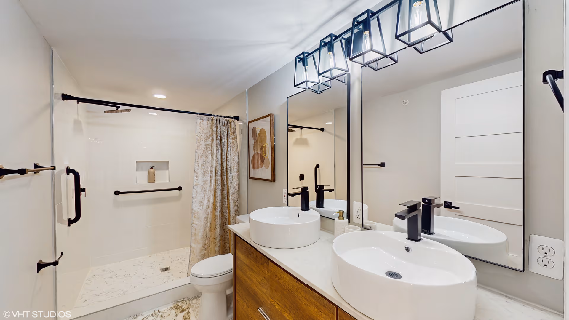 Accessible bathroom with dual sinks, a shower, grab bars, and a large mirror.