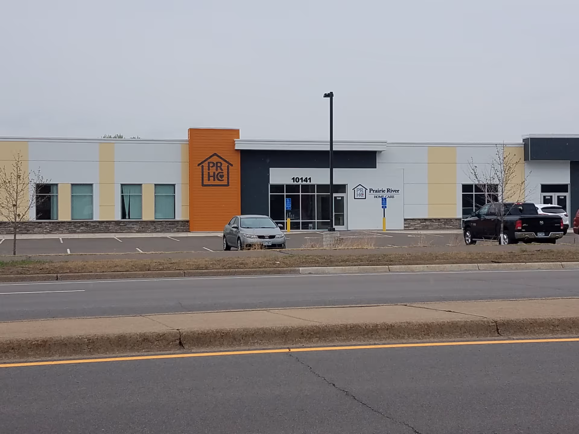 Exterior view of a modern, single-story medical facility with orange accent.