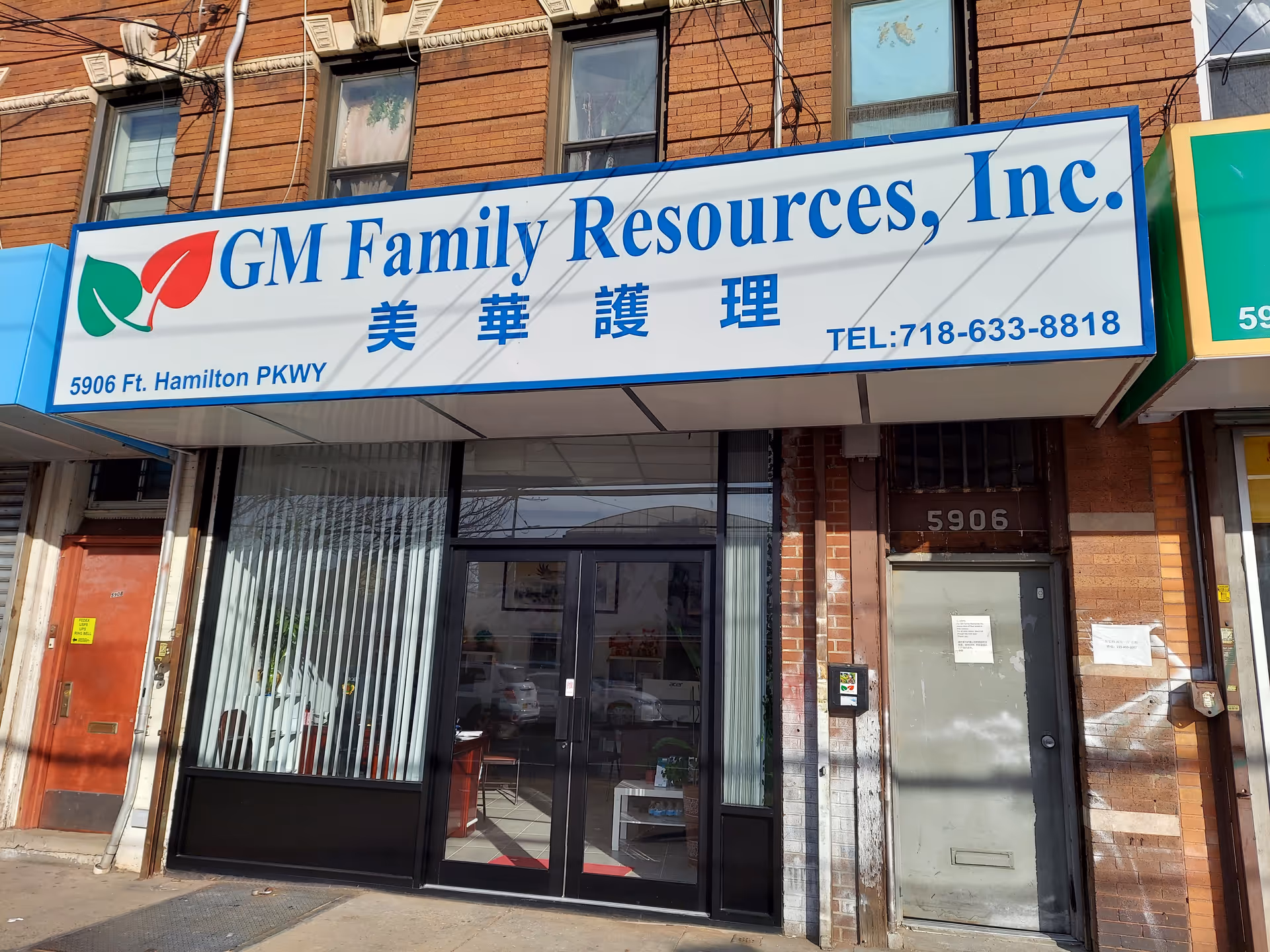 Storefront sign reads GM Family Resources, Inc. on brick building with glass doorway.