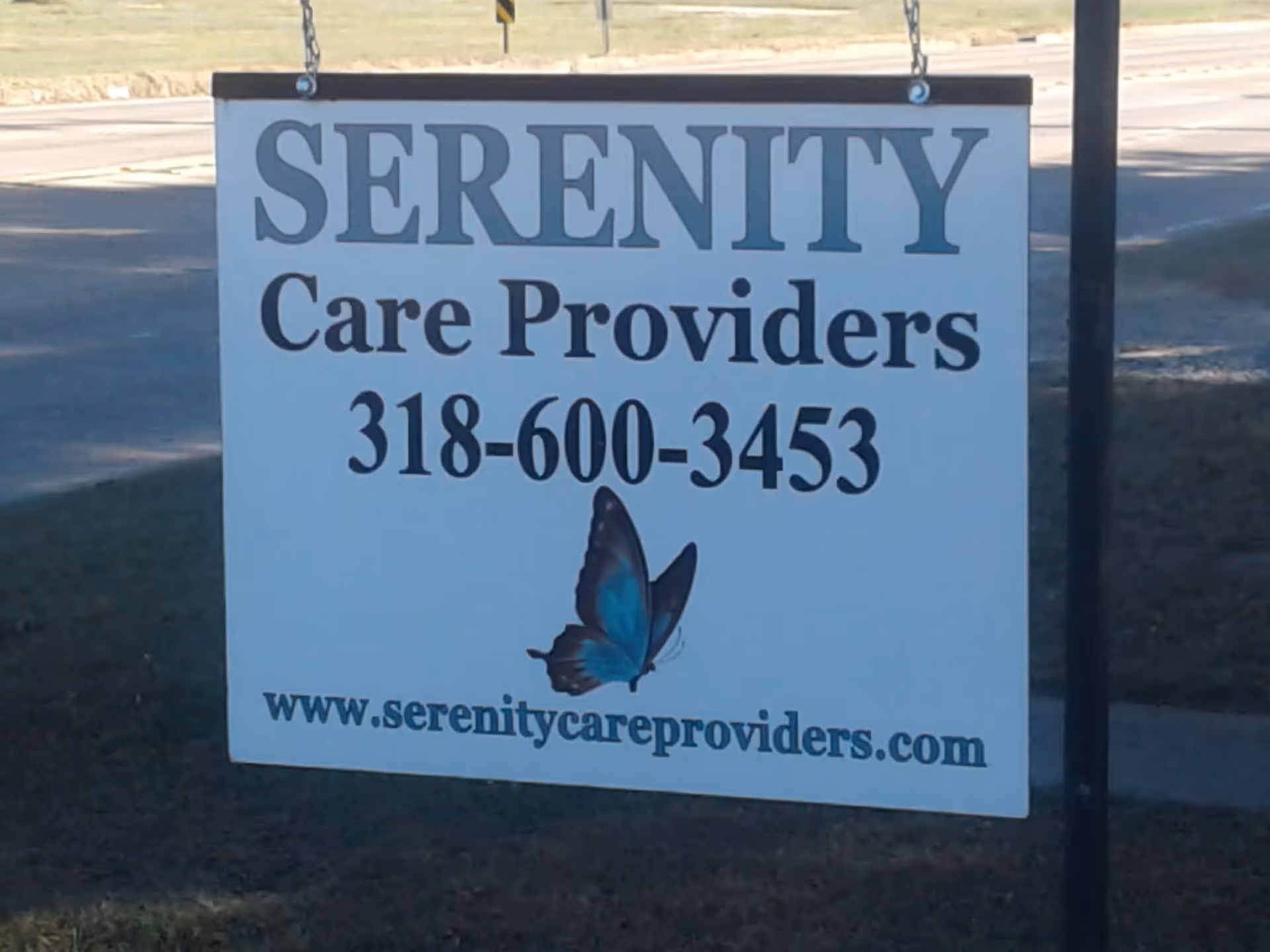 Large outdoor sign reading Serenity Care Providers with butterfly graphic