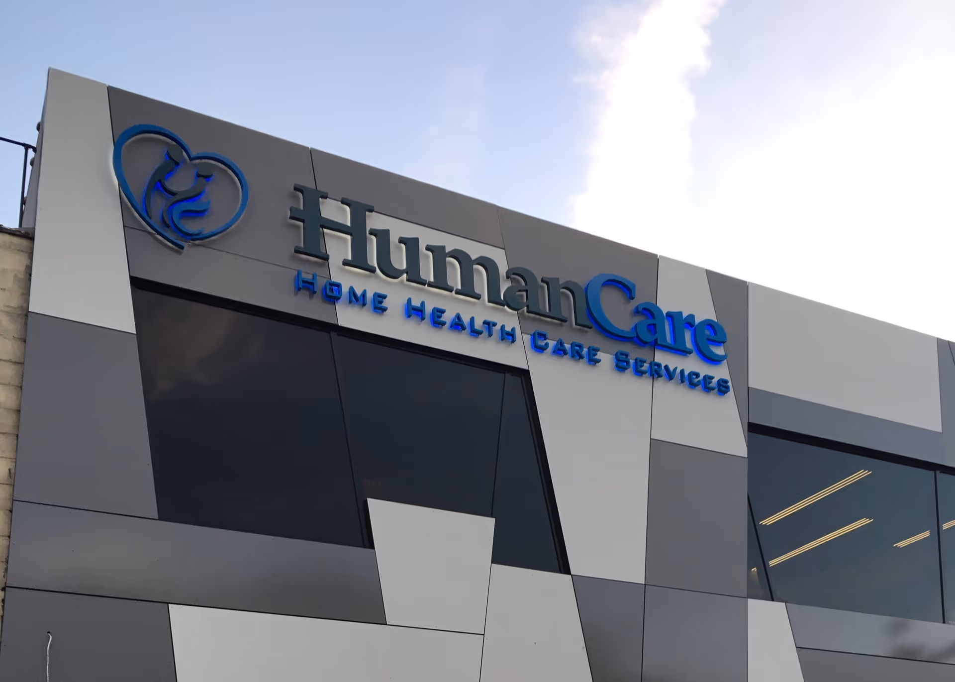 Exterior view of a modern building facade with HumanCare signage and blue logo.