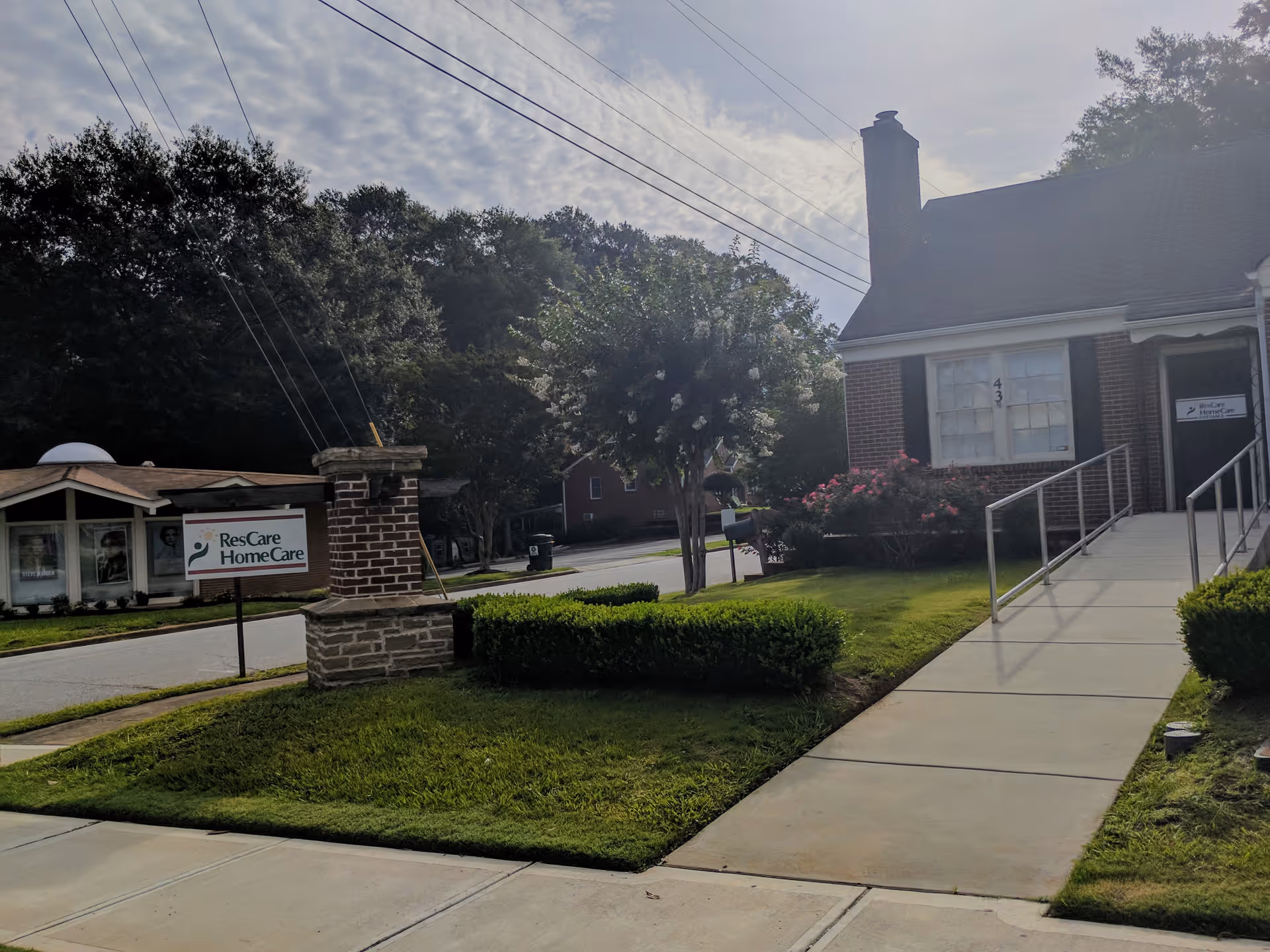Exterior view of a senior care facility entrance with ramp and sign