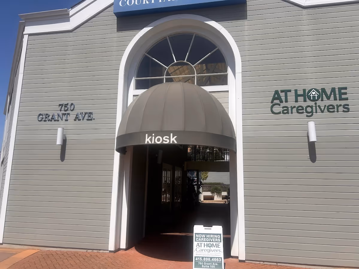 Exterior view of At Home Caregivers building with kiosk entrance and address sign