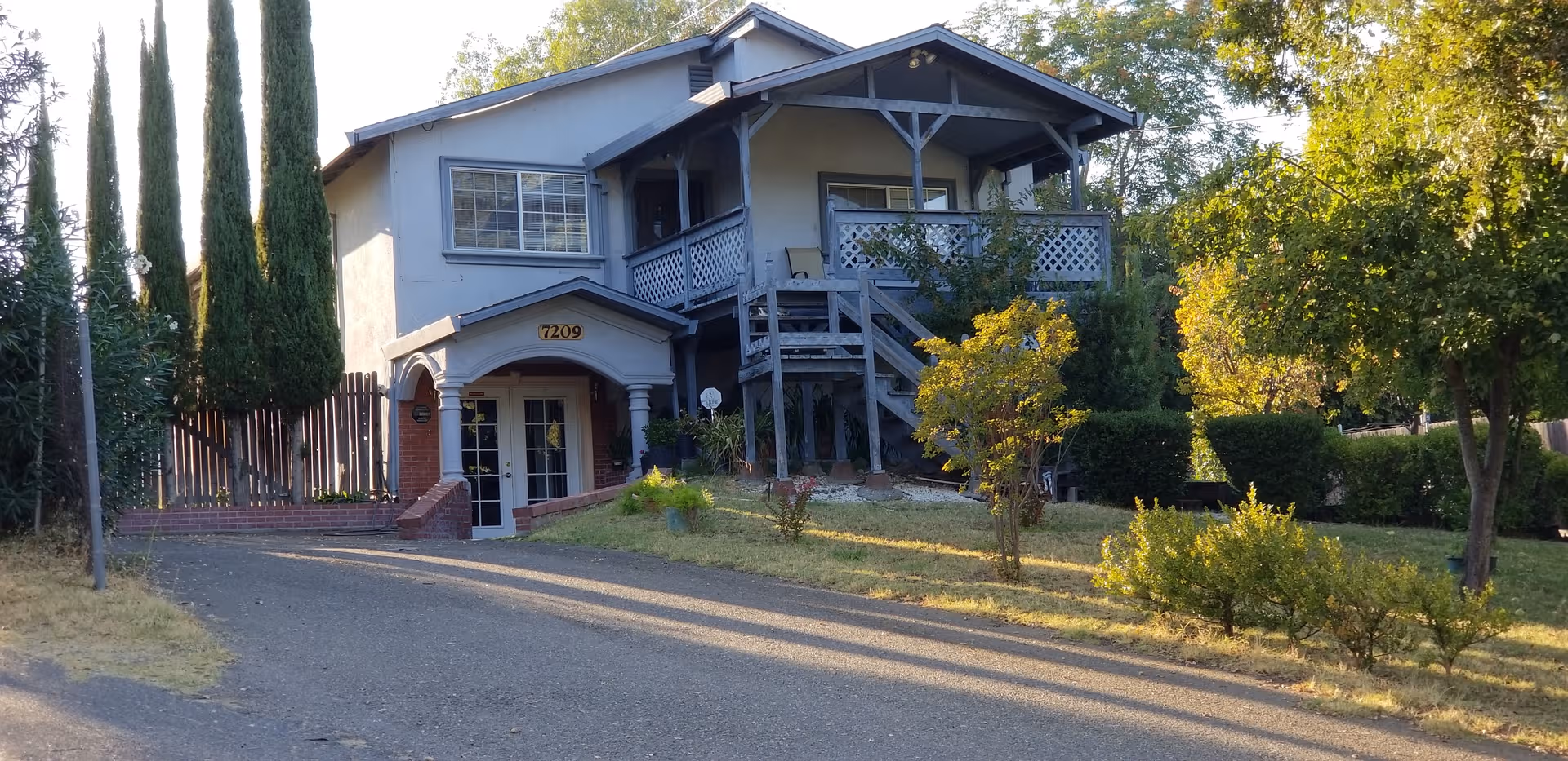 Front exterior of Shady Oaks Home Care, a two-story building with a balcony and external stairs.
