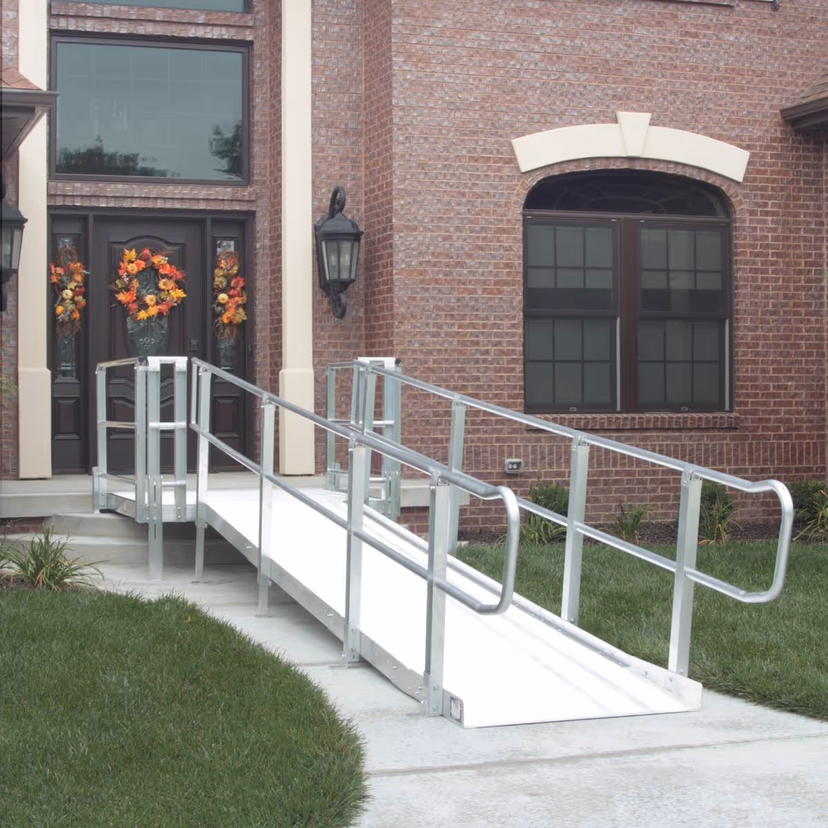Brick facility exterior with ramp to front entrance and autumn wreaths.