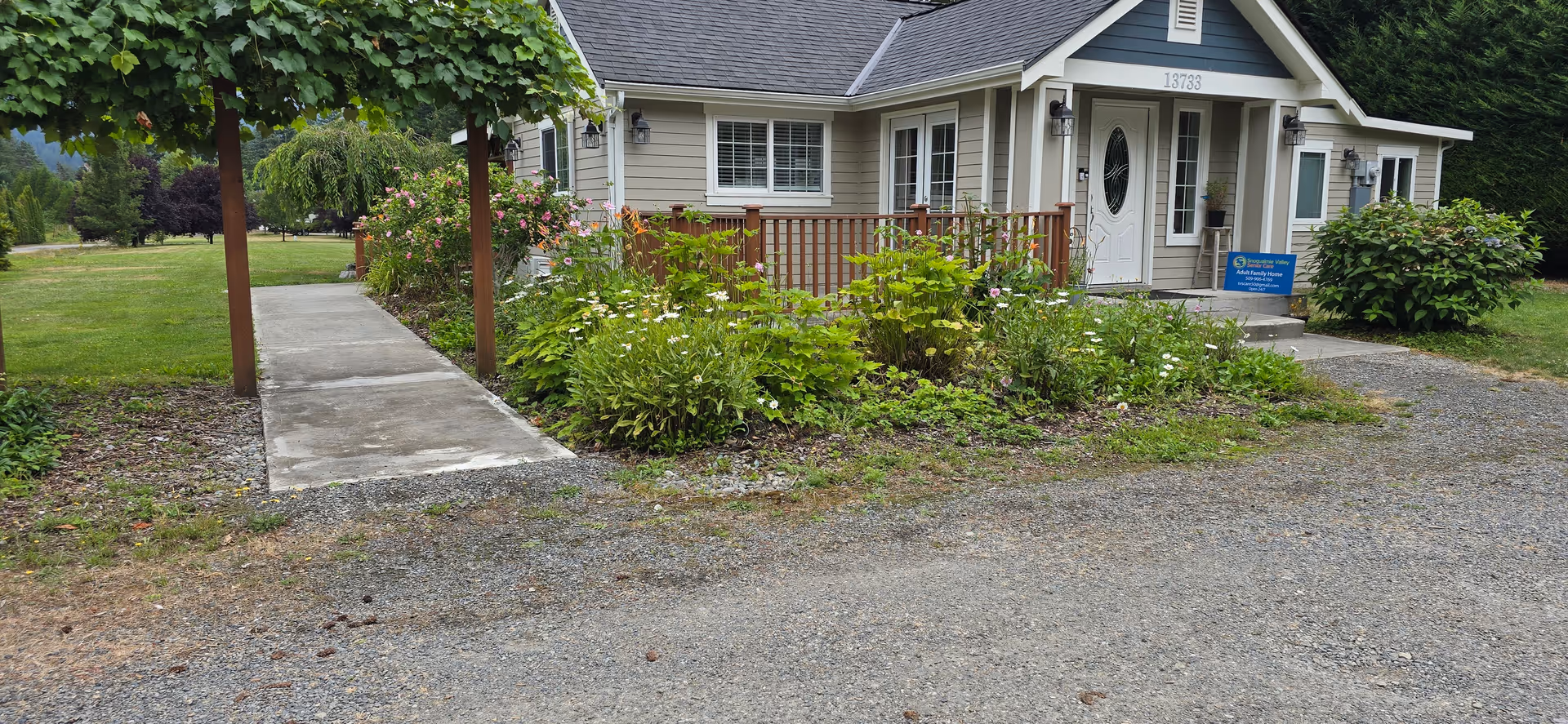 Front exterior of Snoqualmie Valley Senior Care building with walkway and garden.