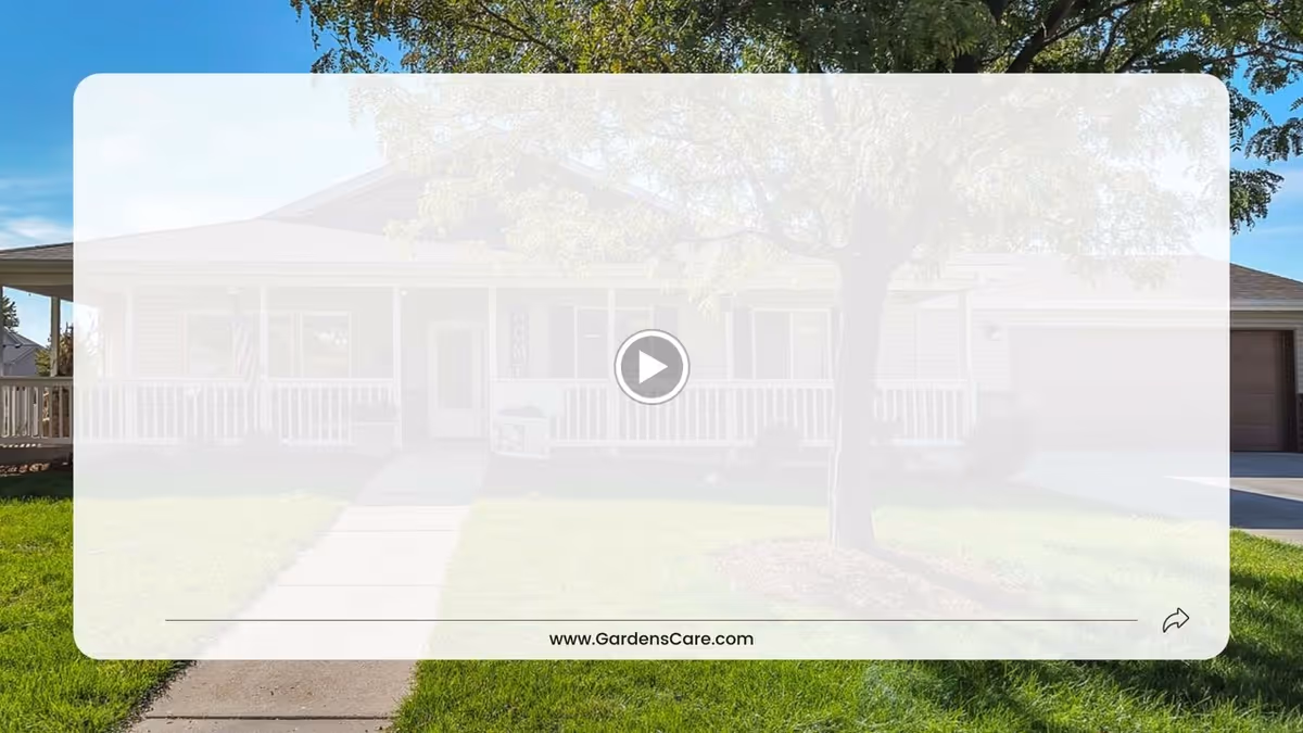 Single-story residential building with a front porch, white railing, and a tree in the front yard. A concrete walkway leads from the sidewalk to the porch. The sky is clear and blue.