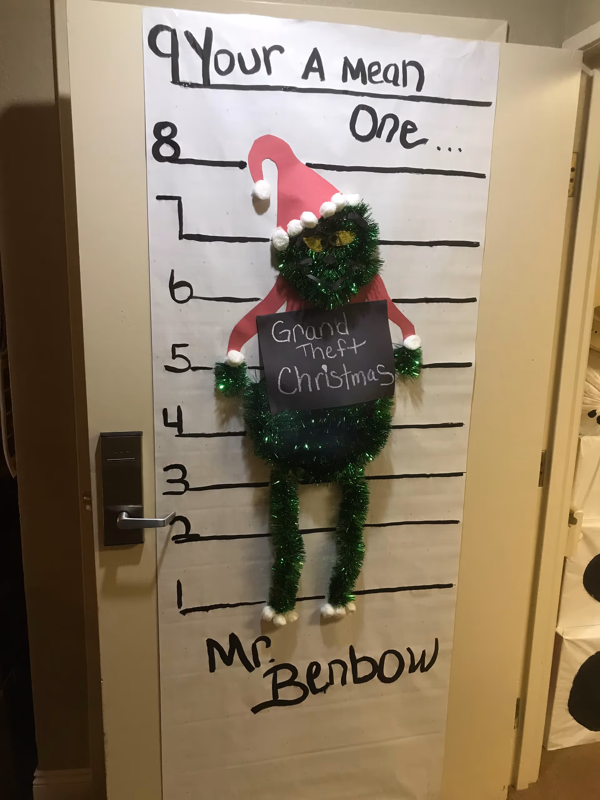 Interior door decorated with a Grinch-themed height chart and a 'Mr Benbow' sign.