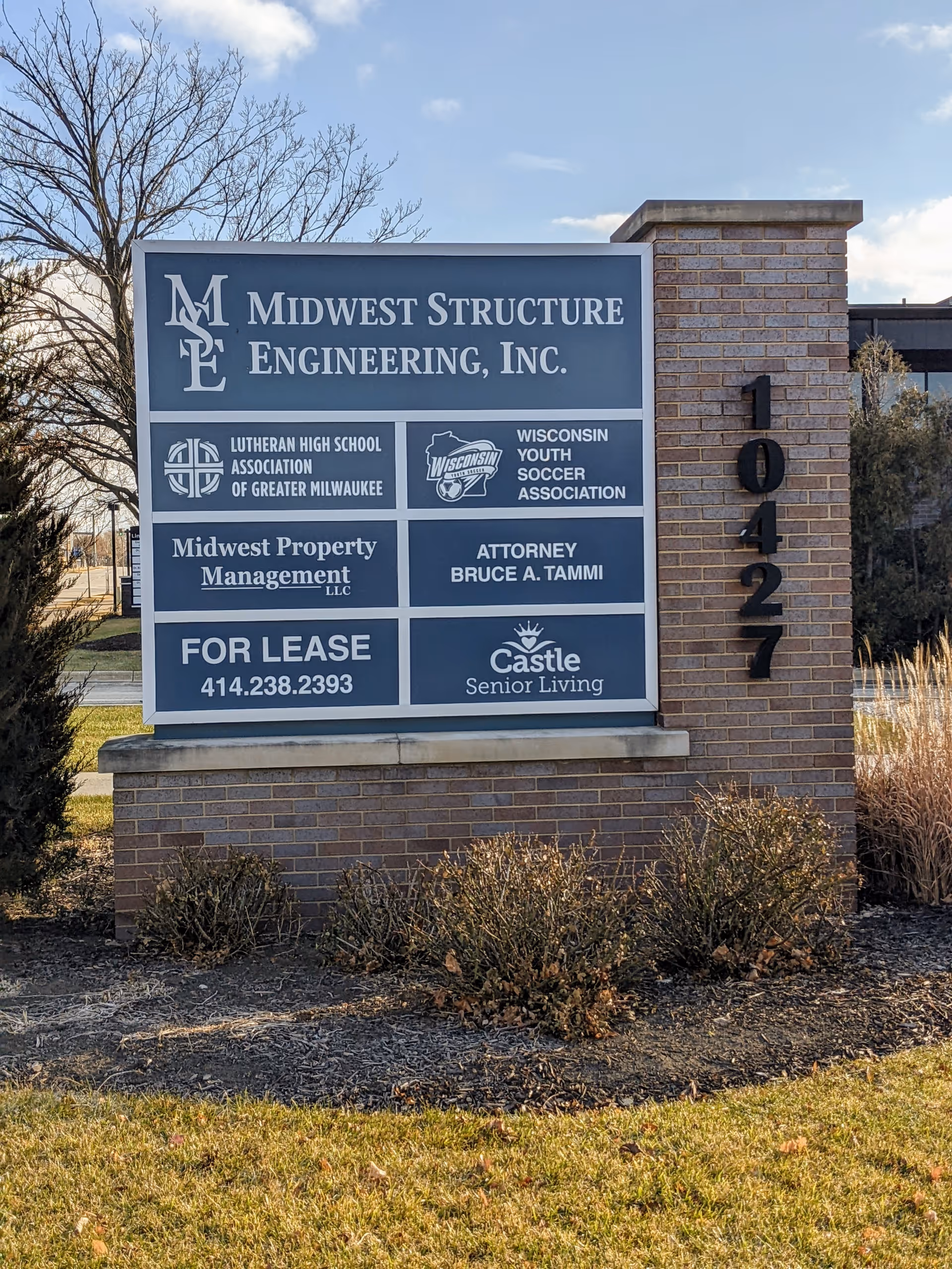 A large brick signage board outdoors displays Castle Senior Living and other tenants with address 10427.