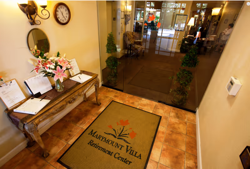 Lobby at Marymount Villa Retirement Center featuring a console table and glass entrance.