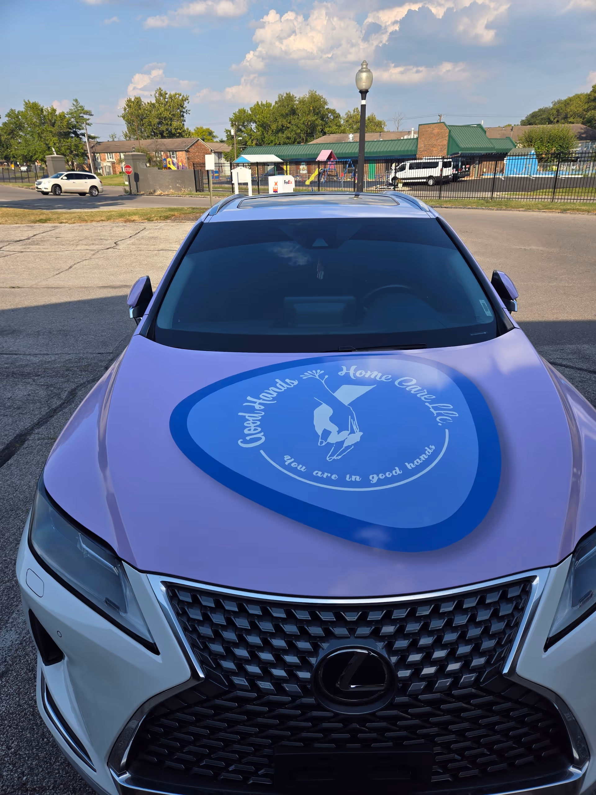 Front view of a purple Lexus with Good Hands Home Care logo on the hood.