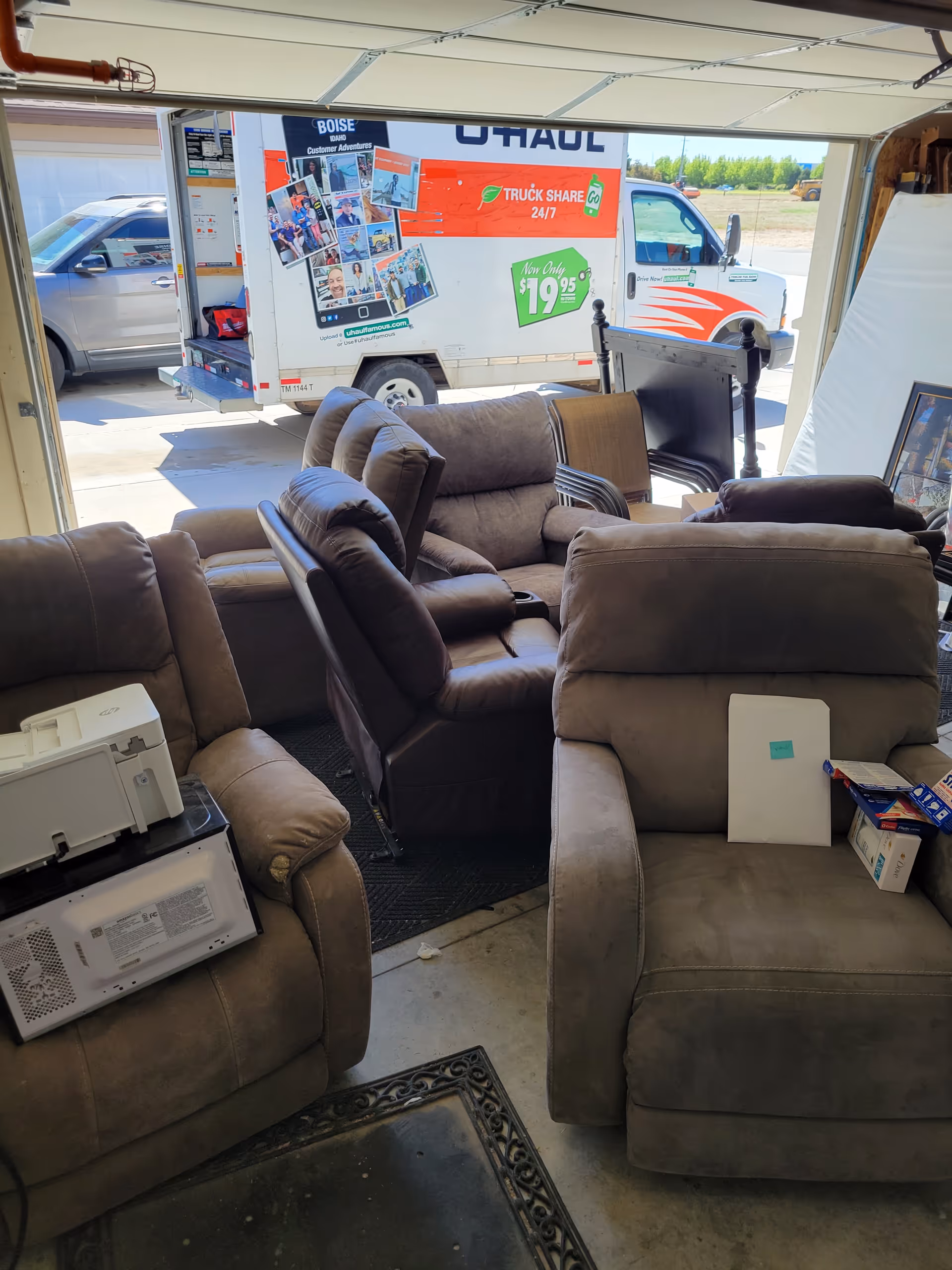 Brown reclining sofas fill a cozy living room setup inside a garage-like space.