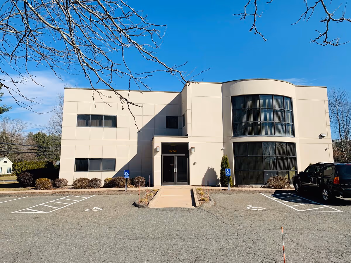 Exterior view of a modern two-story senior care facility with wheelchair-accessible parking.