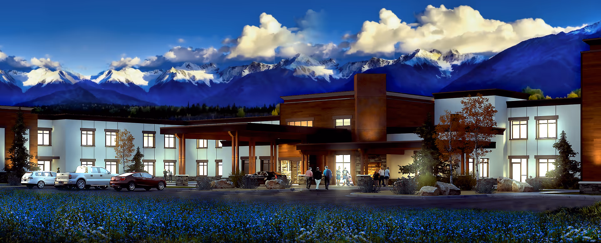 Exterior view of Aspen Creek Senior Living facility with parked cars and mountains in background.