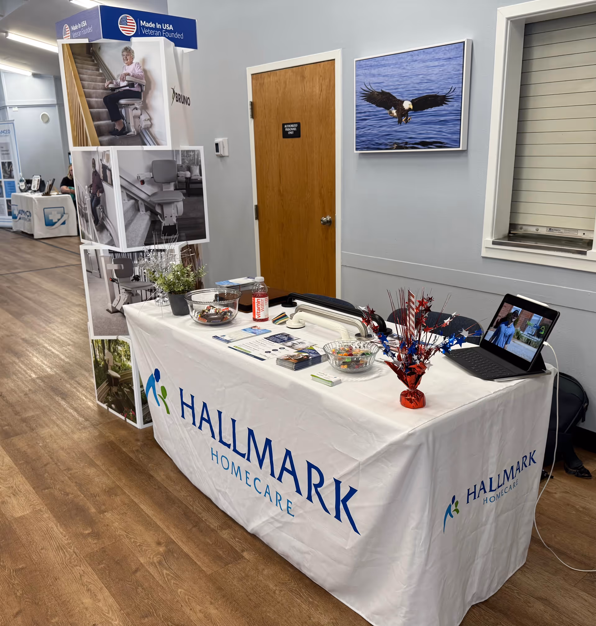 Hallmark Homecare booth with table, brochures, and laptop indoors.