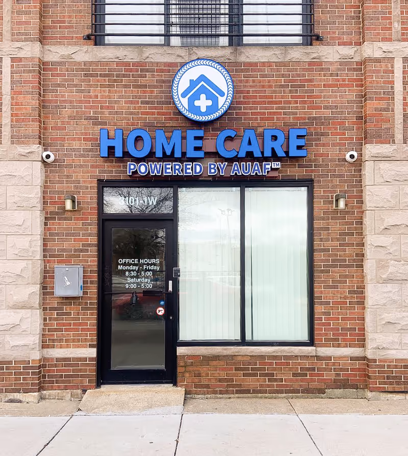 Brick building storefront with a large blue HOME CARE sign and glass entrance.