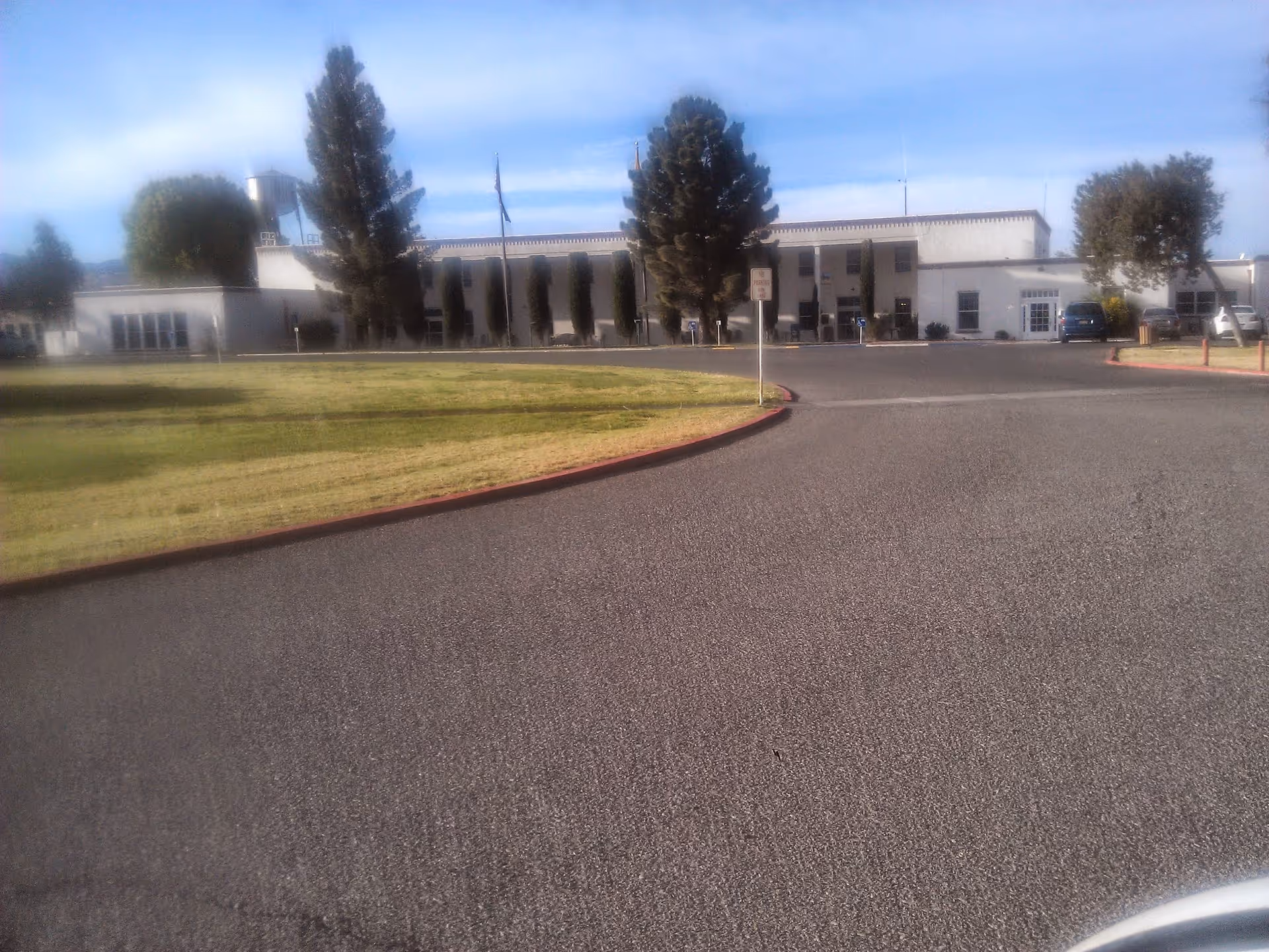 Exterior view of New Mexico State Veterans Home; white single-story building with curved driveway.