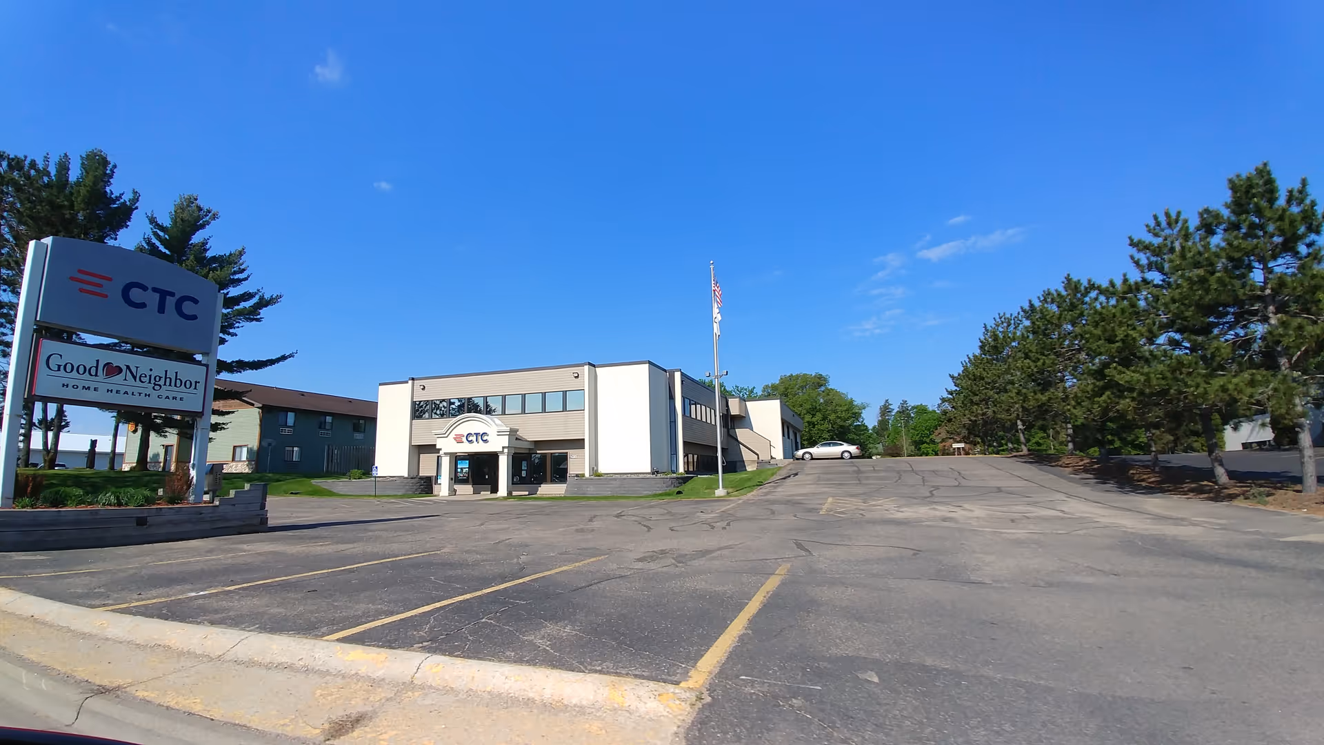 Exterior view of Good Neighbor Home Health Care building with sign and parking lot.