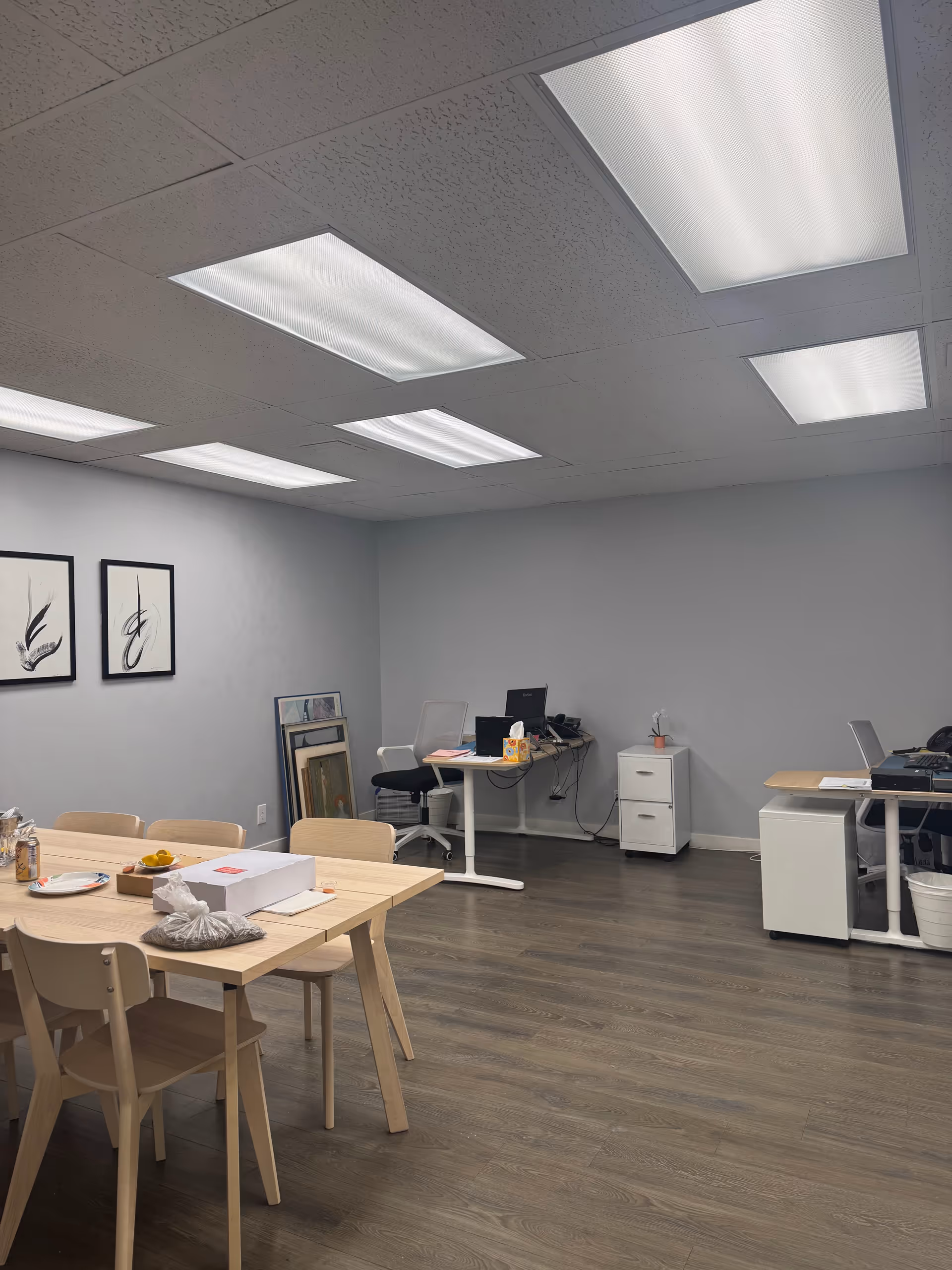 Bright multipurpose room with a dining table, chairs, and computer desks.