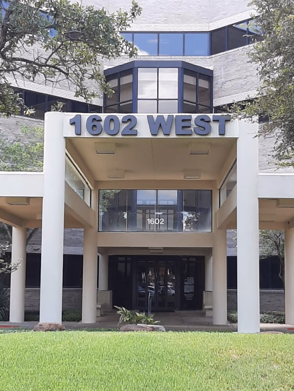 Exterior view of the facility entrance with tall columns and 1602 West sign.