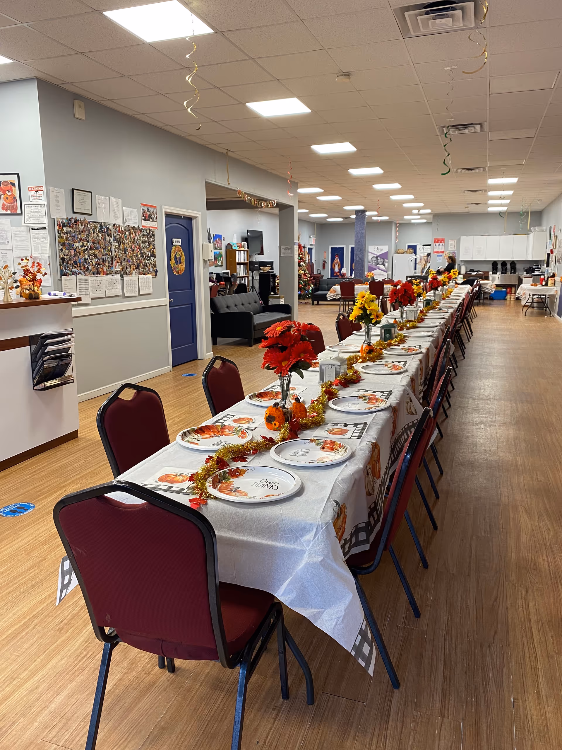 Long banquet table with plates and centerpieces in a brightly lit indoor dining room.