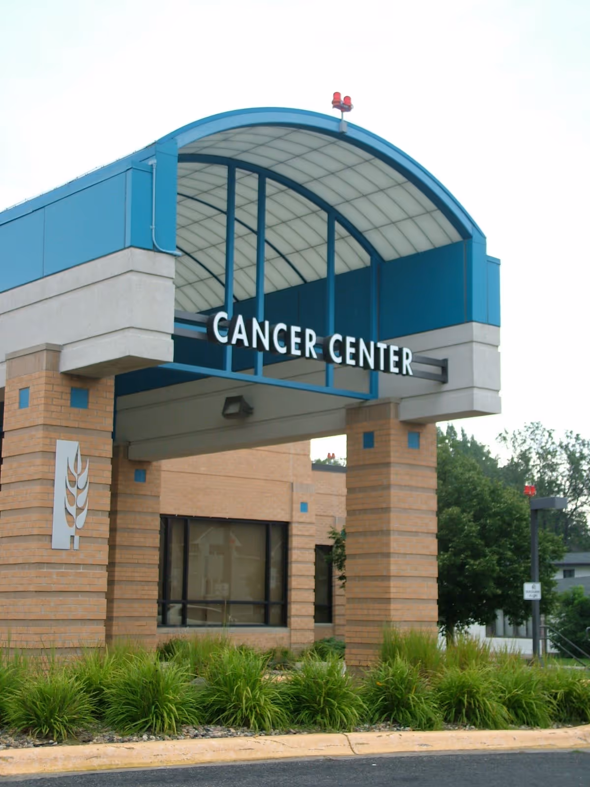 A blue curved canopy covers the Cancer Center entrance at Prairie Lakes Hospital.