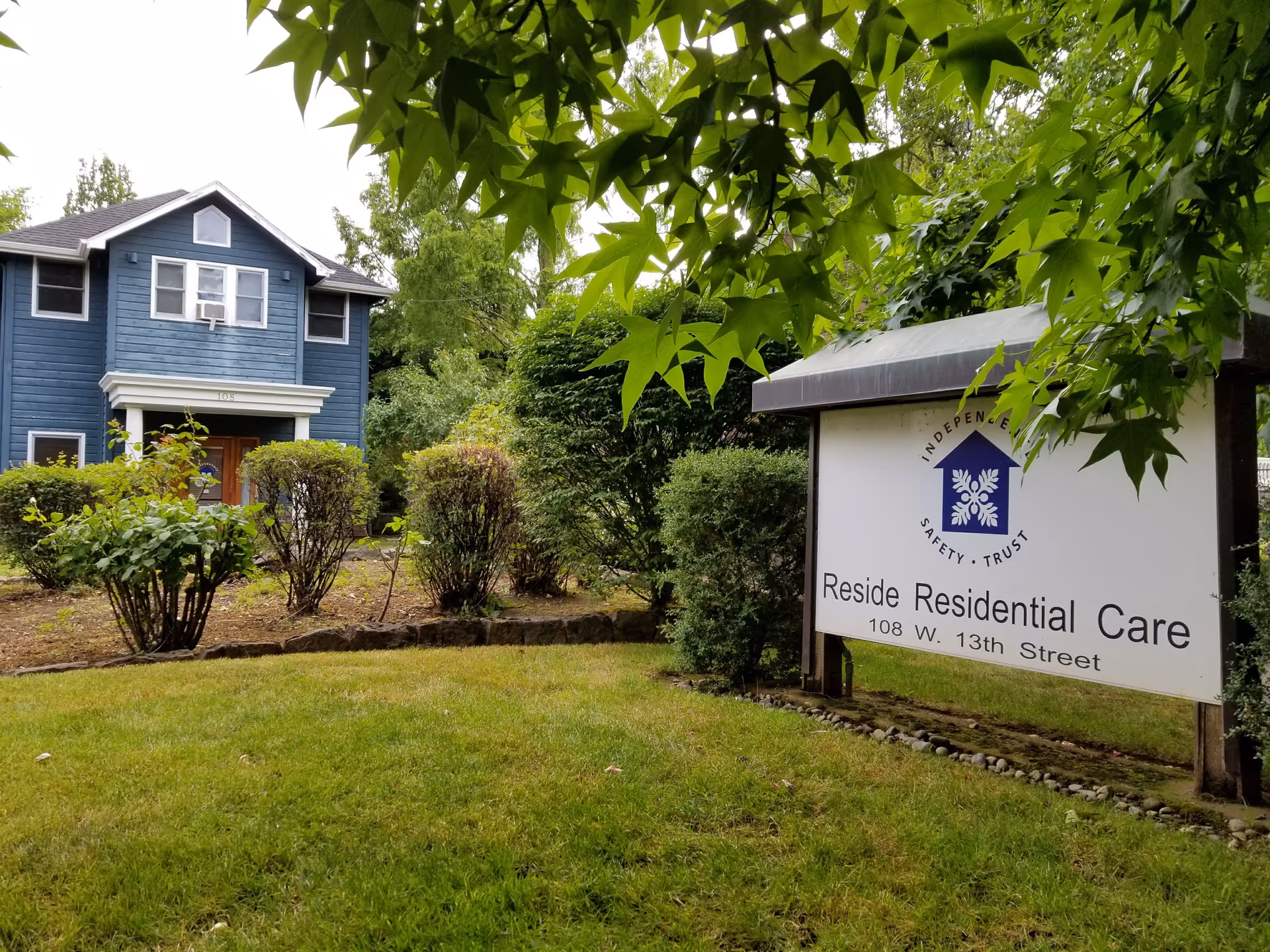 Blue two-story building with a large Reside Residential Care sign in front.
