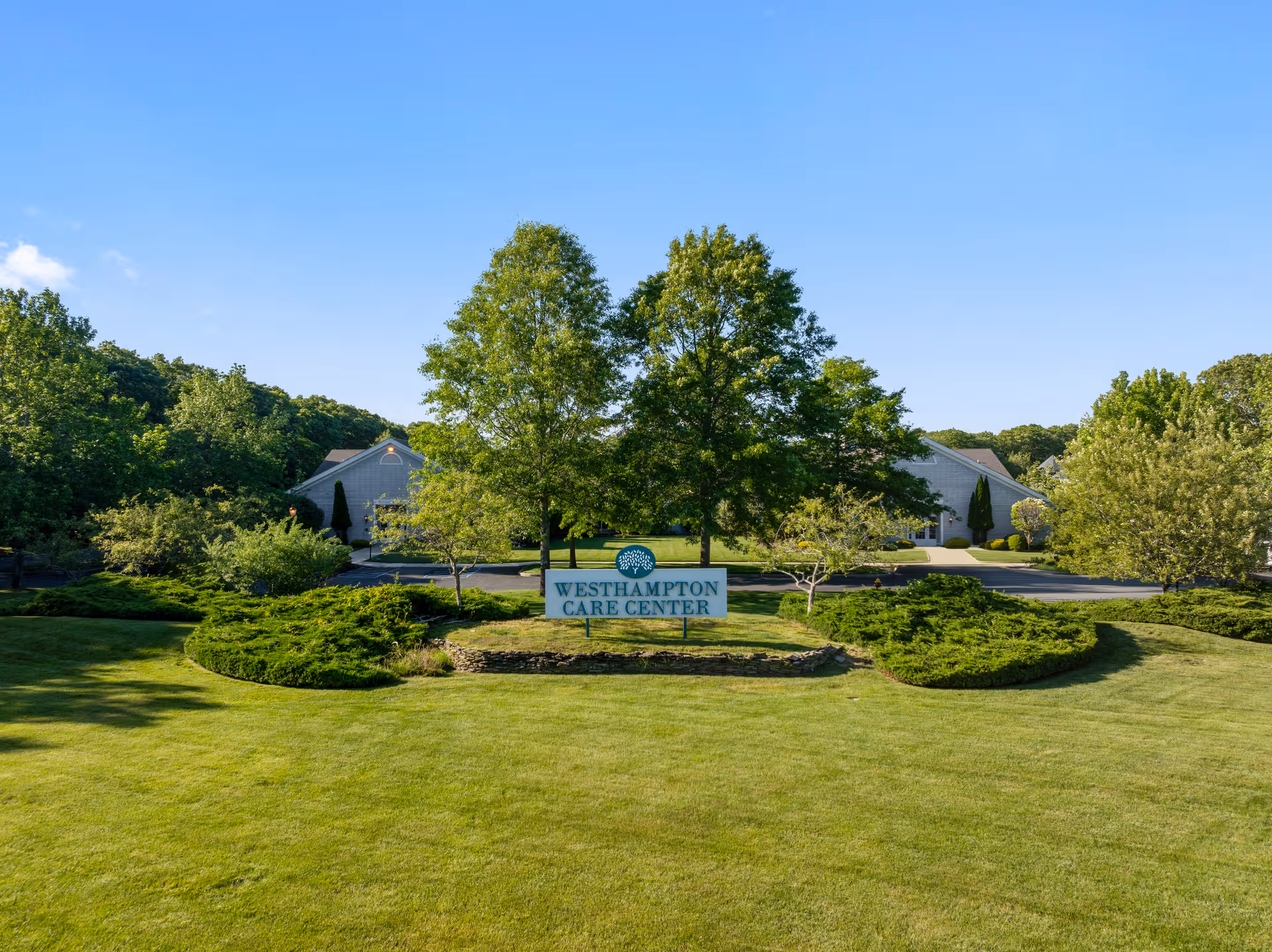 Front view of Westhampton Care Center with a sign on a manicured lawn.