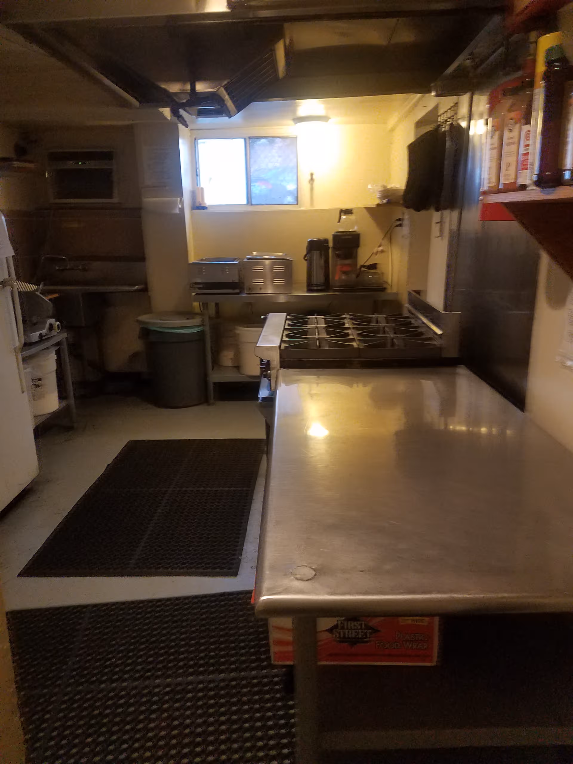 Industrial stainless-steel kitchen with prep table and appliances in a senior facility.