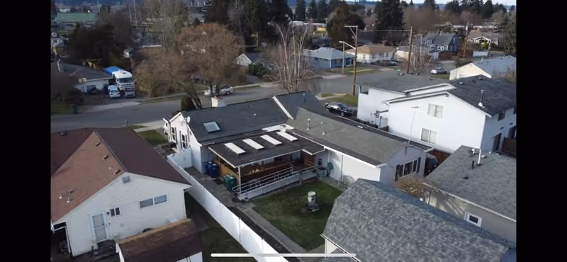 Aerial view of a residential senior living property with interconnected single-story buildings and fenced outdoor areas.