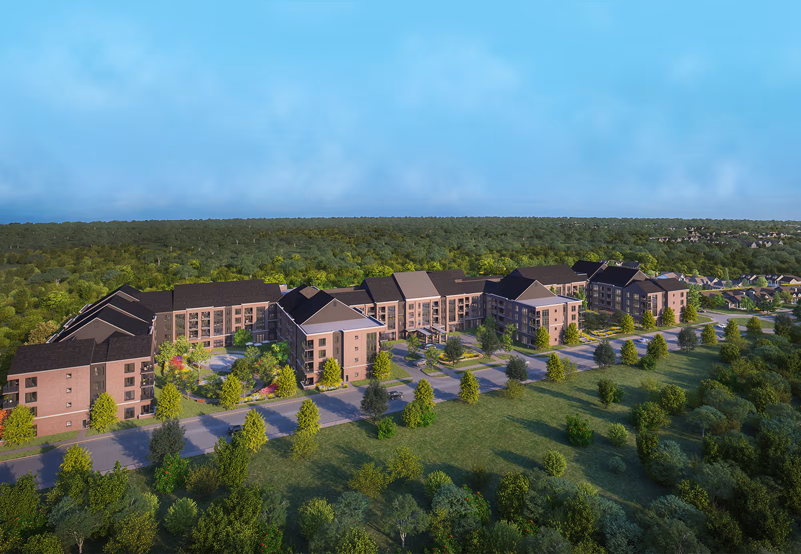 Aerial view of a large senior living facility named The Village at Providence Point surrounded by trees and greenery under a blue sky.