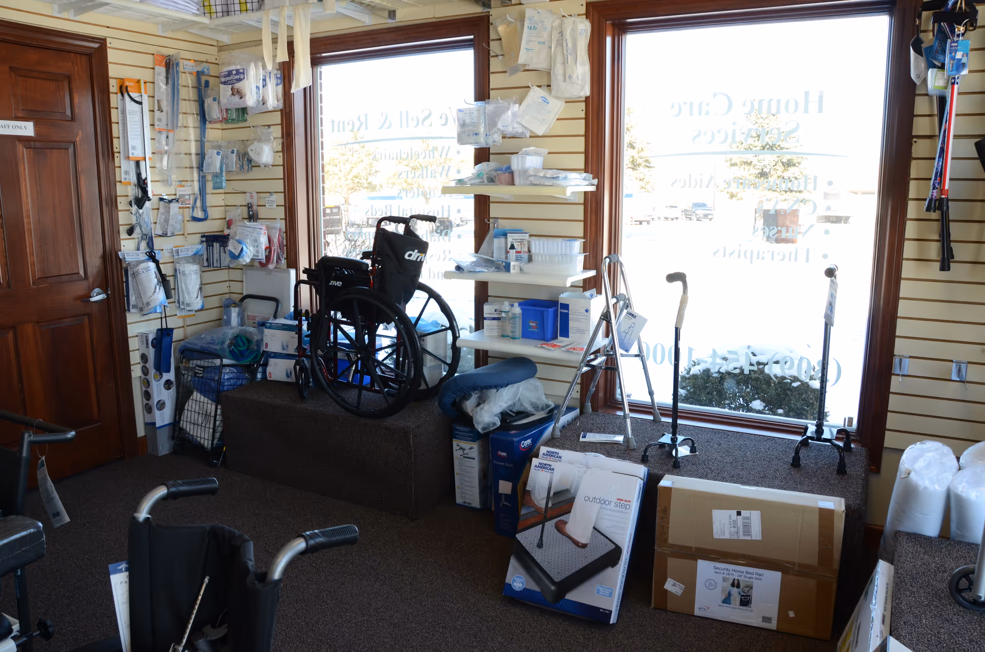 Interior of a medical supply room with wheelchairs, walkers, and boxed equipment.