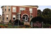 Brick building with arched entrance and a Gafney Home sign in front.