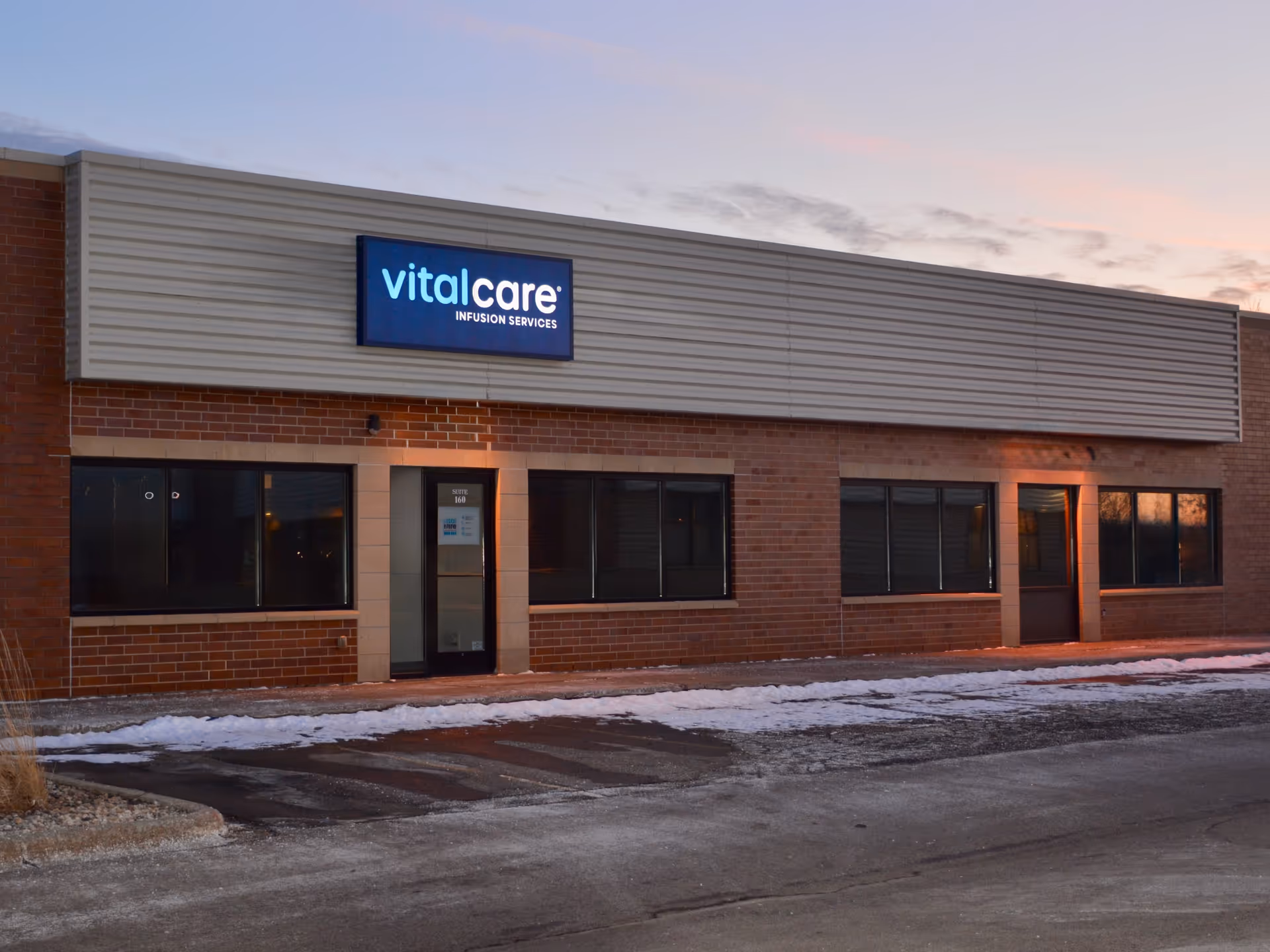 Exterior view of Vital Care Infusion Services of Madison building with brick facade and sign.