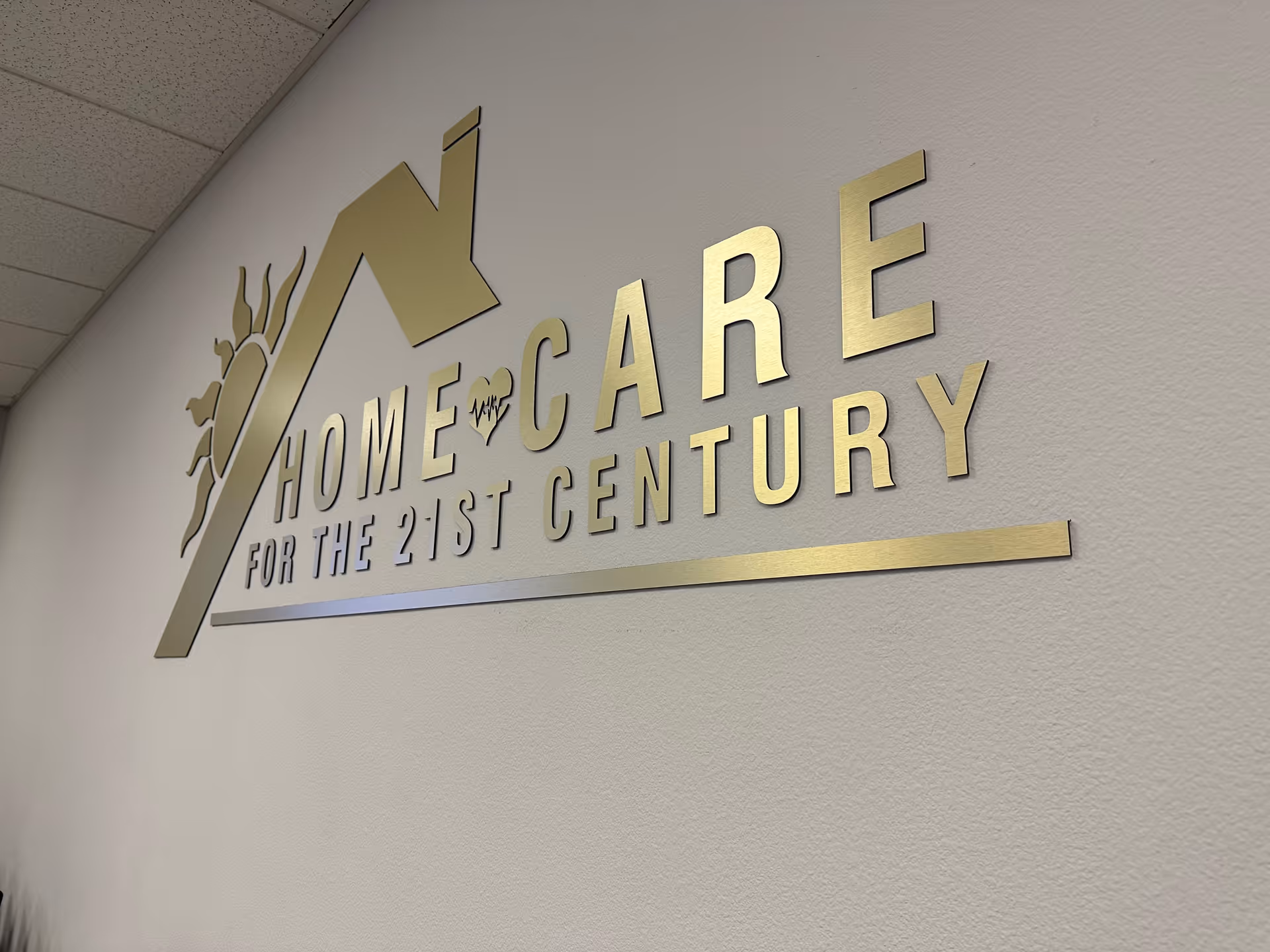 Gold letters form a 'Home Care for the 21st Century' sign on a textured interior wall.