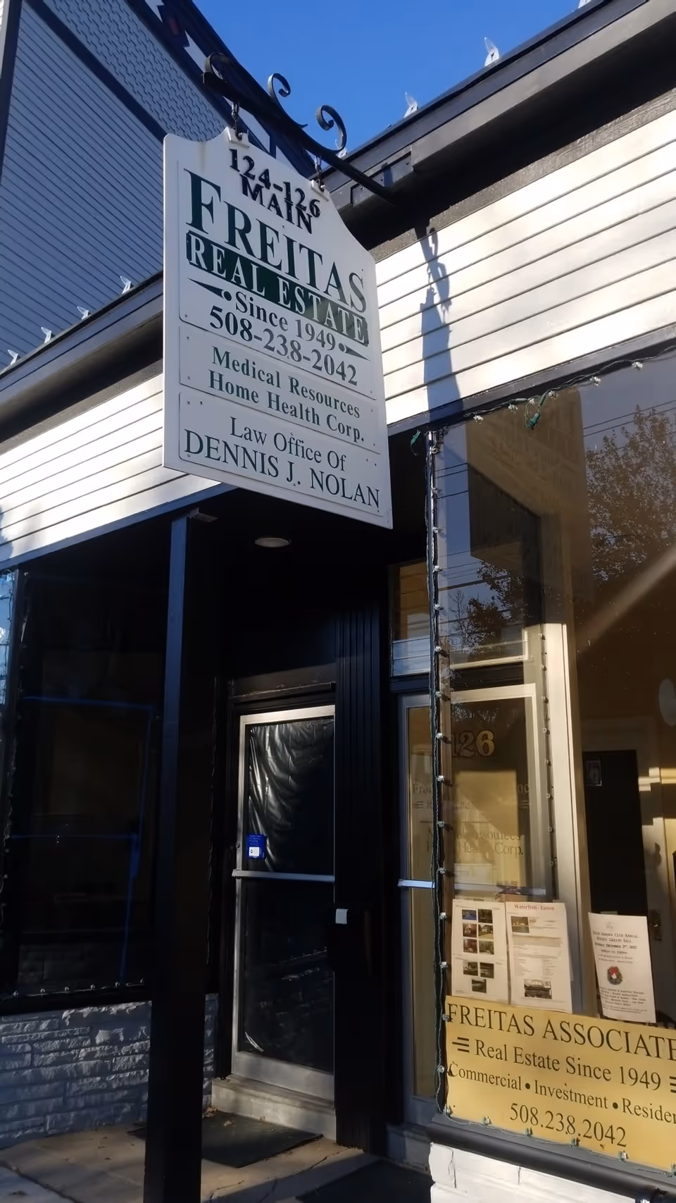 Exterior storefront with Freitas Real Estate sign and glass entrance.