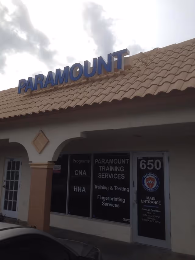 Exterior view of Paramount Training Services storefront with a blue sign on a tiled roof.