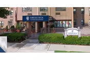 Front view of Throgs Neck Rehabilitation and Nursing Center entrance with walkway and greenery.