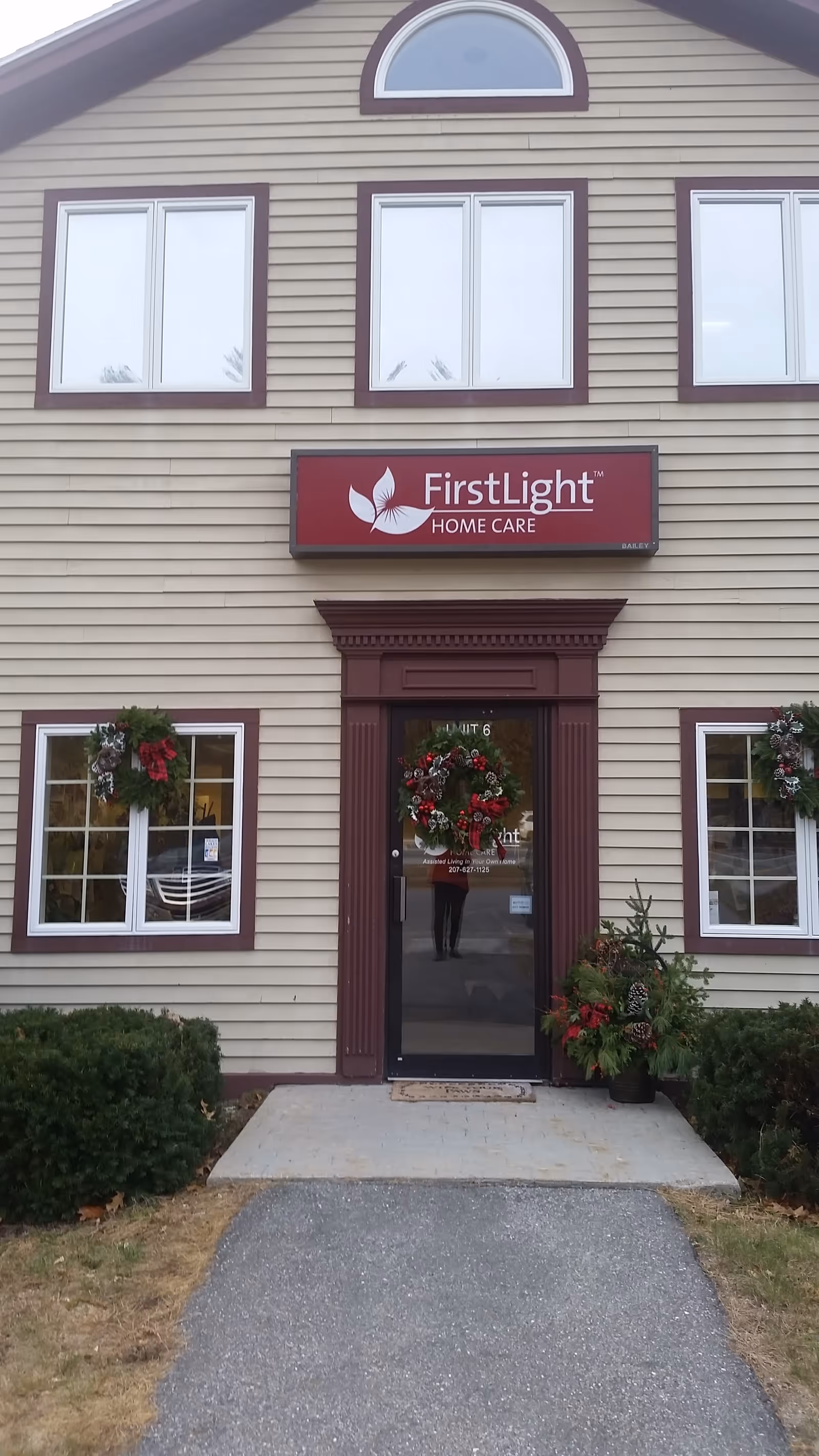 Exterior view of FirstLight Home Care entrance with holiday wreaths on windows.