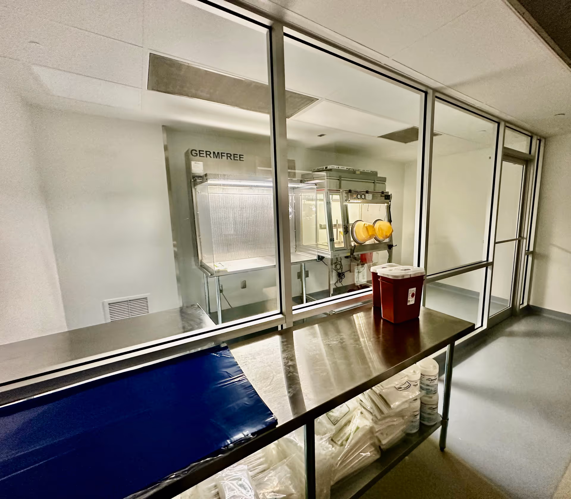 Stainless steel counter beside a glass-walled sterile room labeled GERMFREE