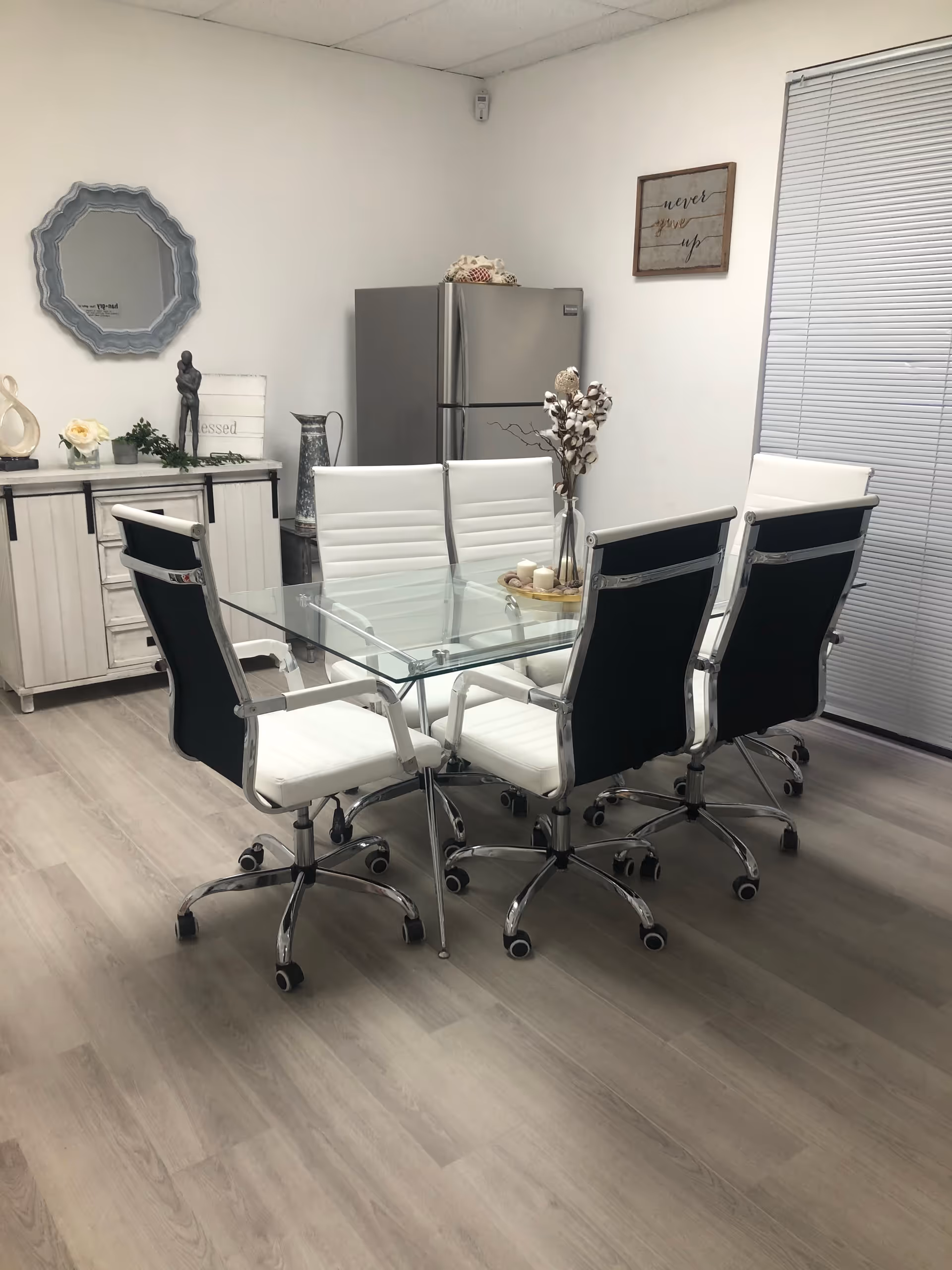 Modern dining room with glass table and white and black swivel chairs.