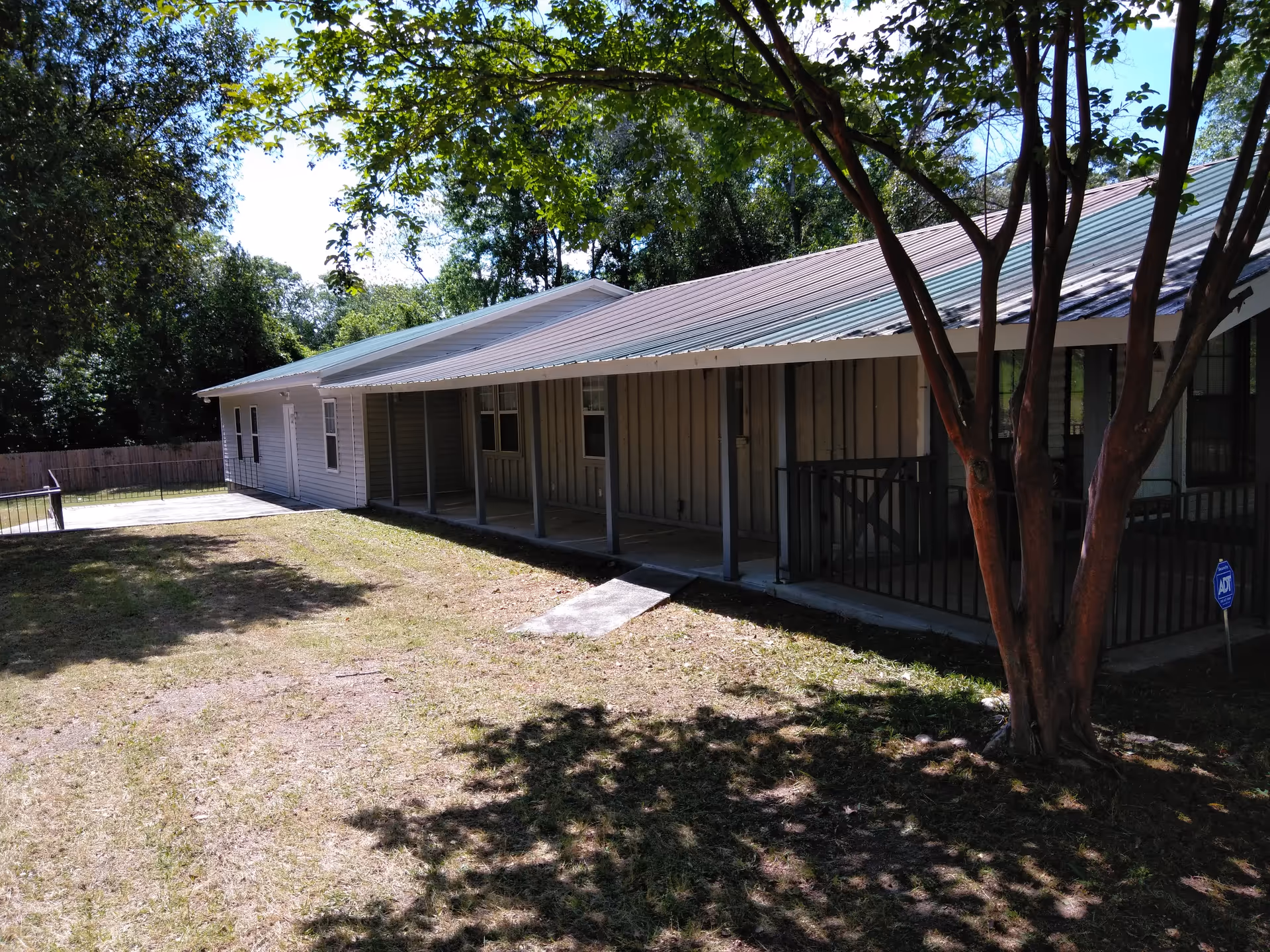 Exterior view of House of Love on Sibley: a white, single-story building with a covered porch.