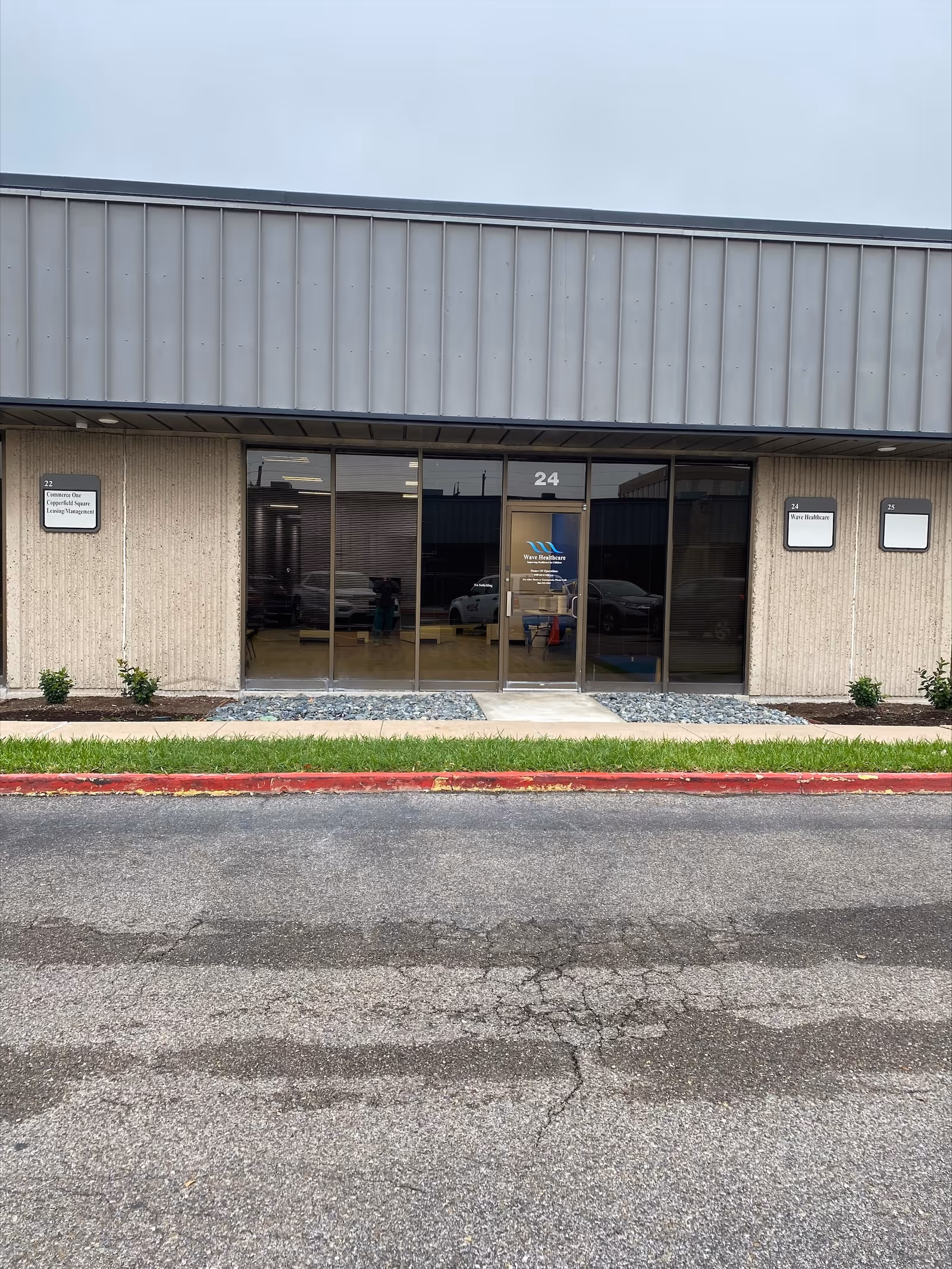Front entrance of Wave Healthcare Corpus Christi with glass doors labeled 24.