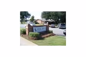 Entrance sign for Warner Robins Rehabilitation Center with parked cars nearby.