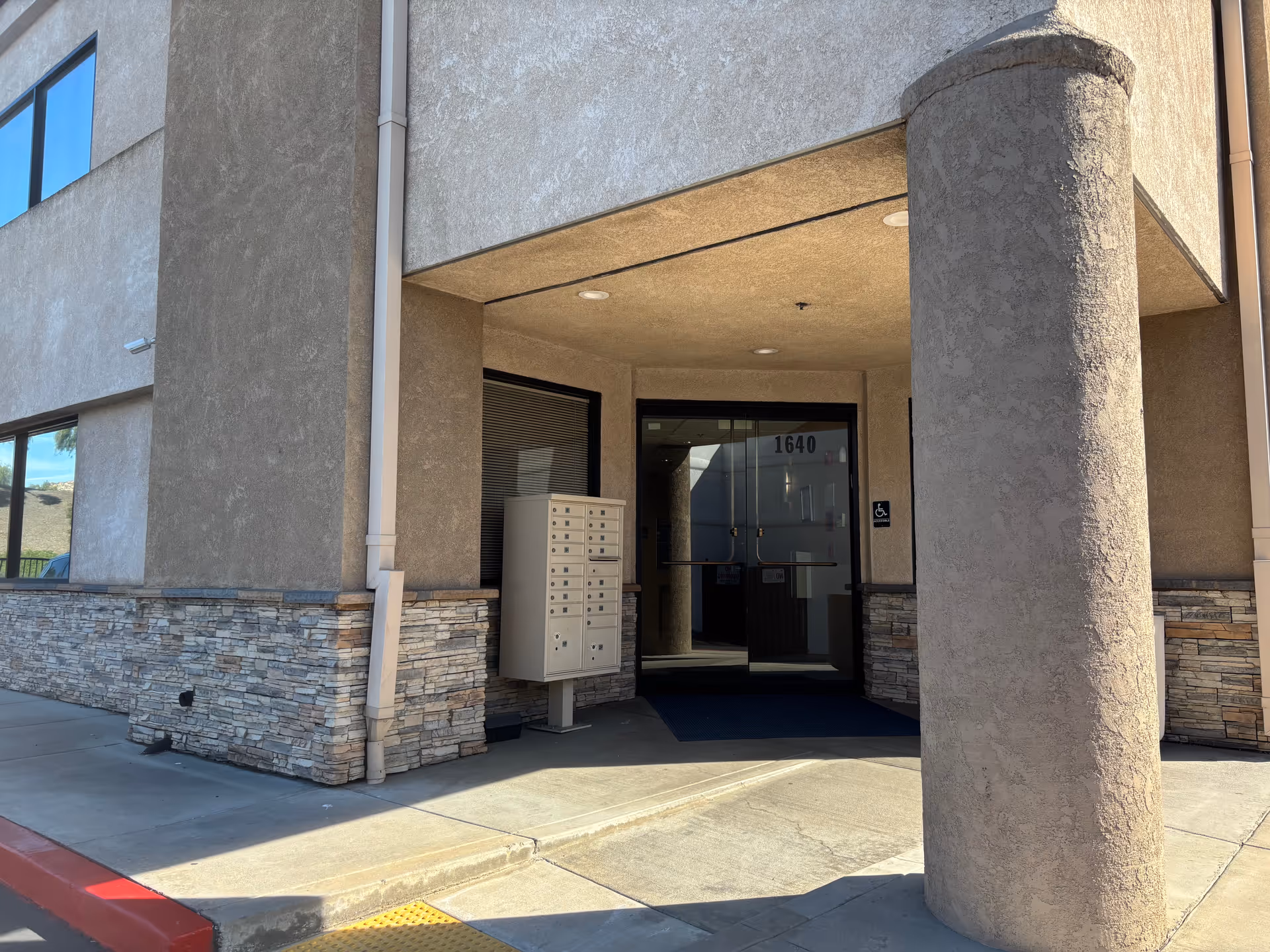Exterior entrance of A Place at Home Inland Empire West with pillars and glass door