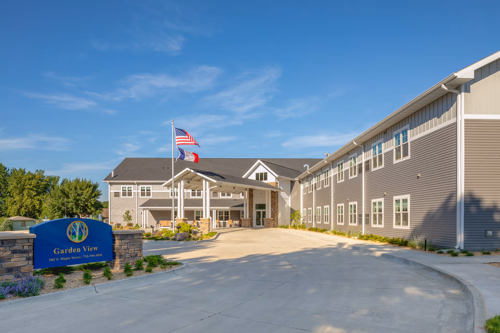 Front exterior of Garden View Assisted Living featuring the entrance and flagpoles.